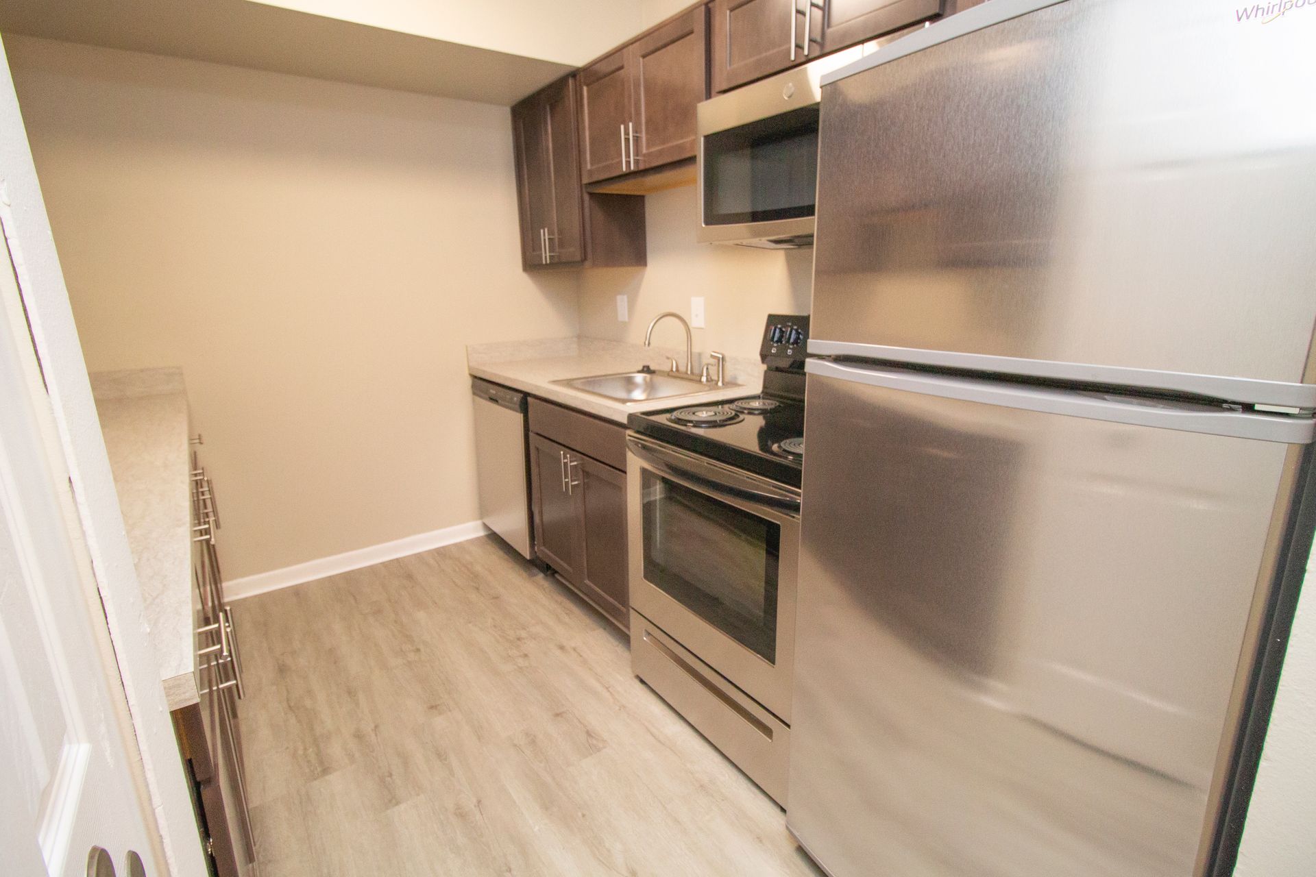A kitchen with stainless steel appliances and wooden floors