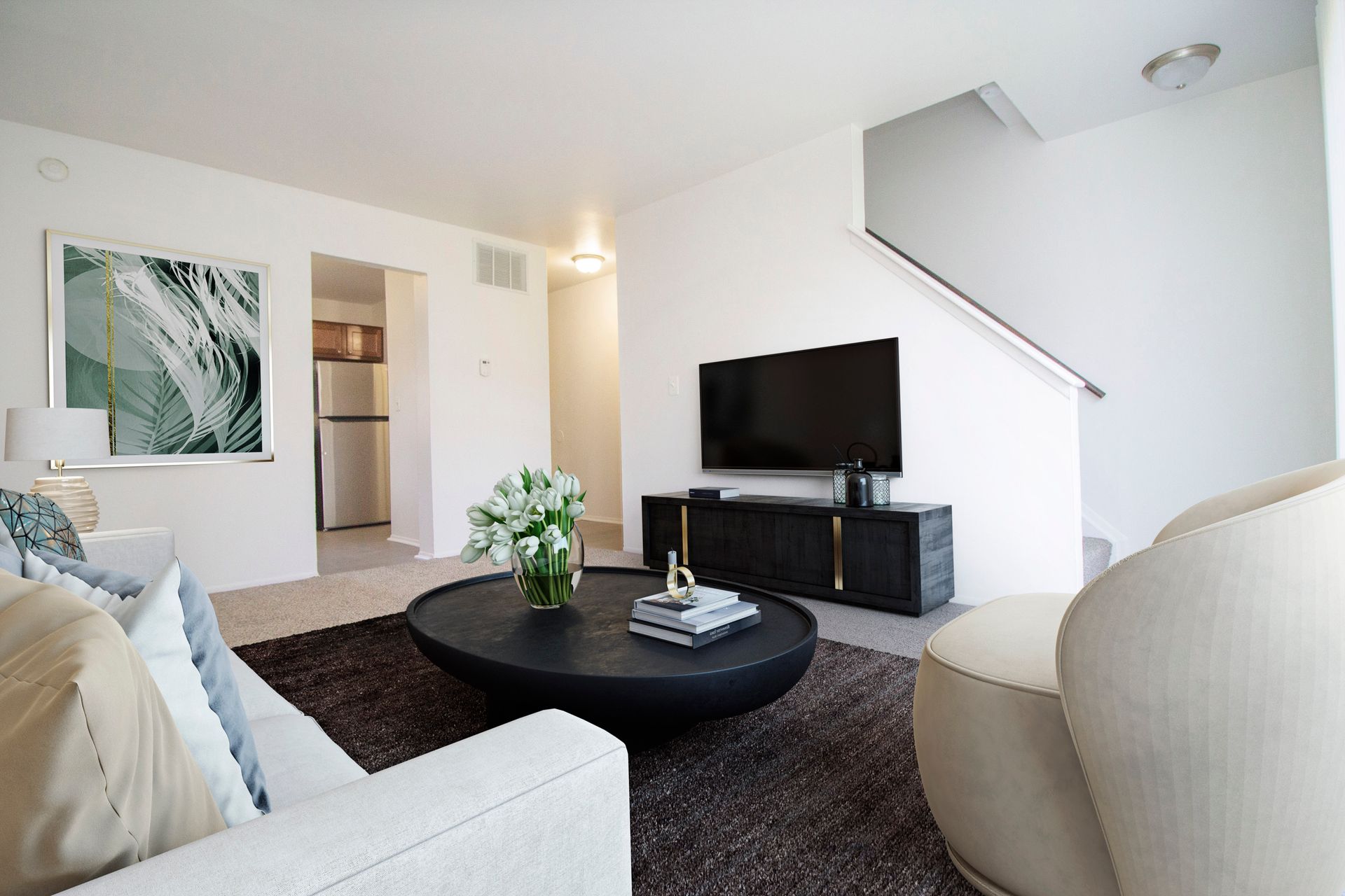 A living room with a couch , chair , coffee table and television