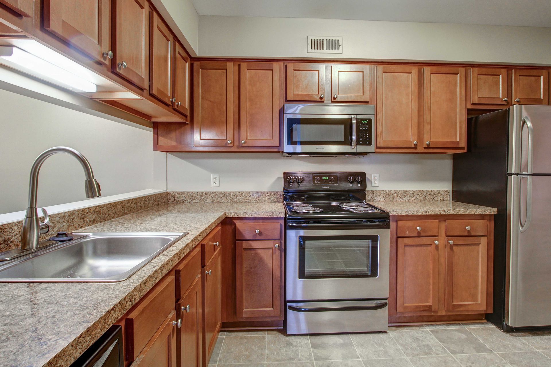 A kitchen with stainless steel appliances and wooden cabinets