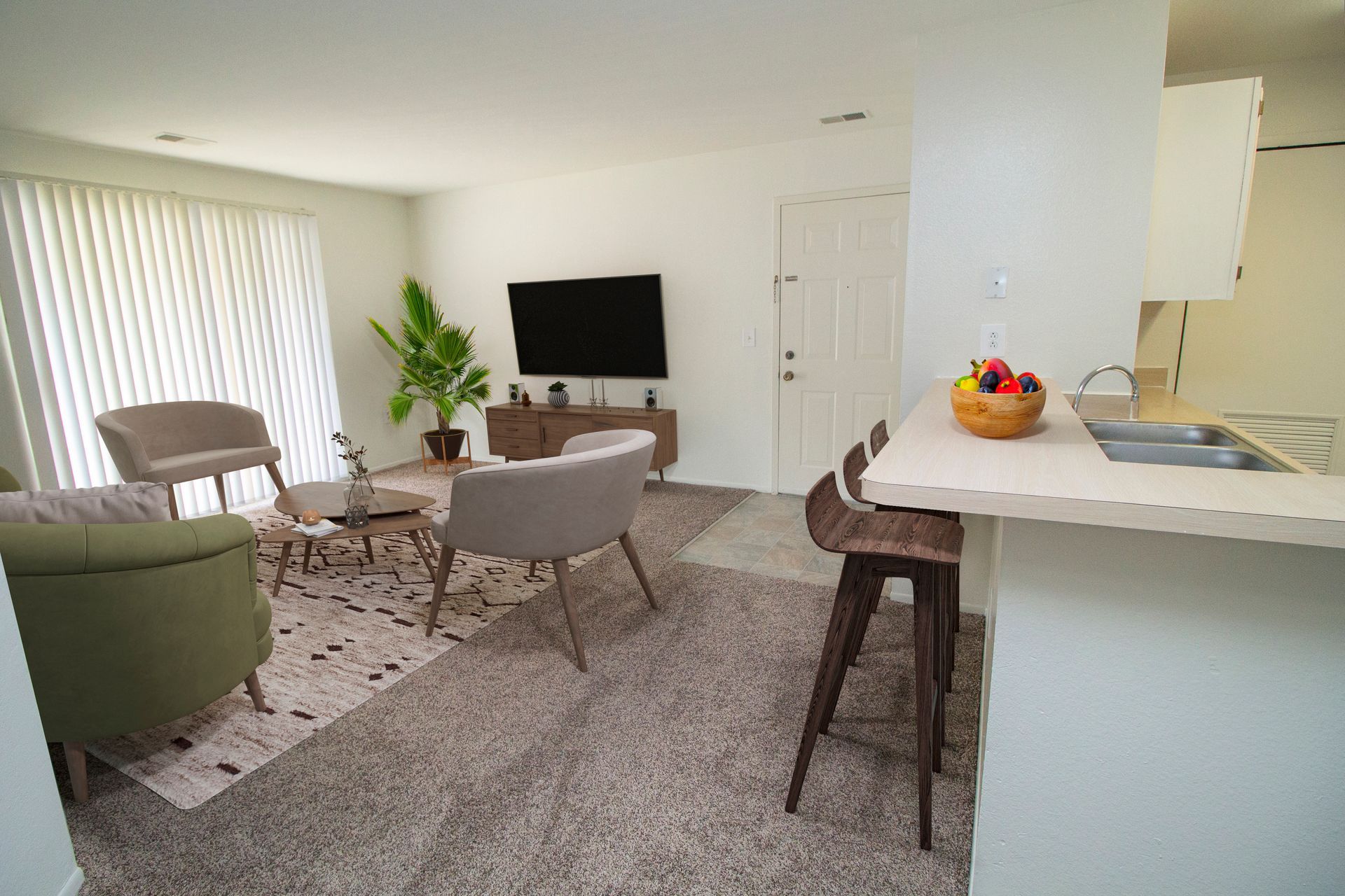 A living room with a flat screen tv and a kitchen
