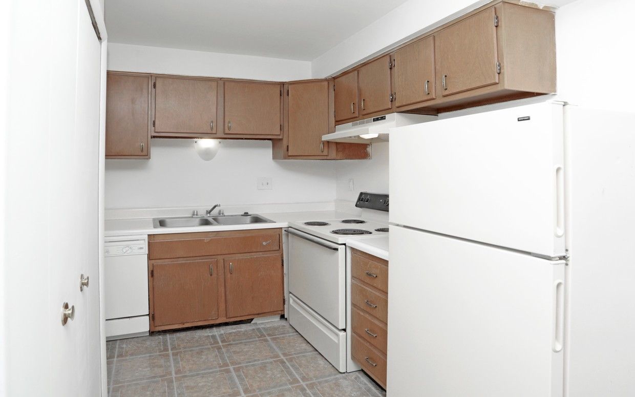 A kitchen with wooden cabinets and a white refrigerator