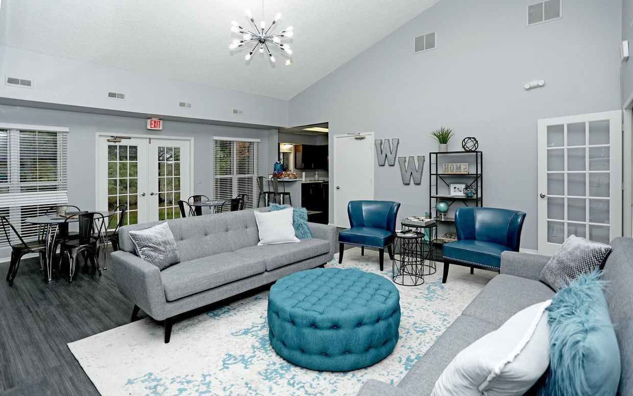 A living room filled with furniture and a blue ottoman.