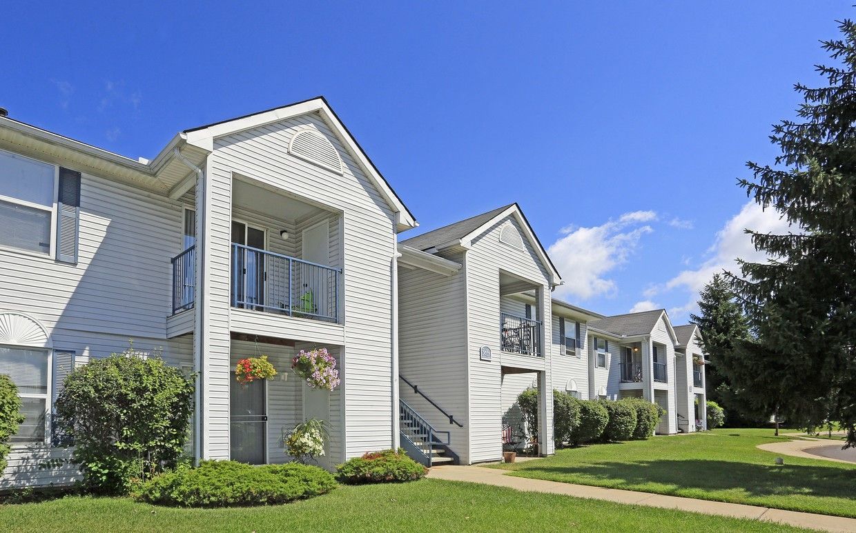 A white apartment building with a blue sky in the background.