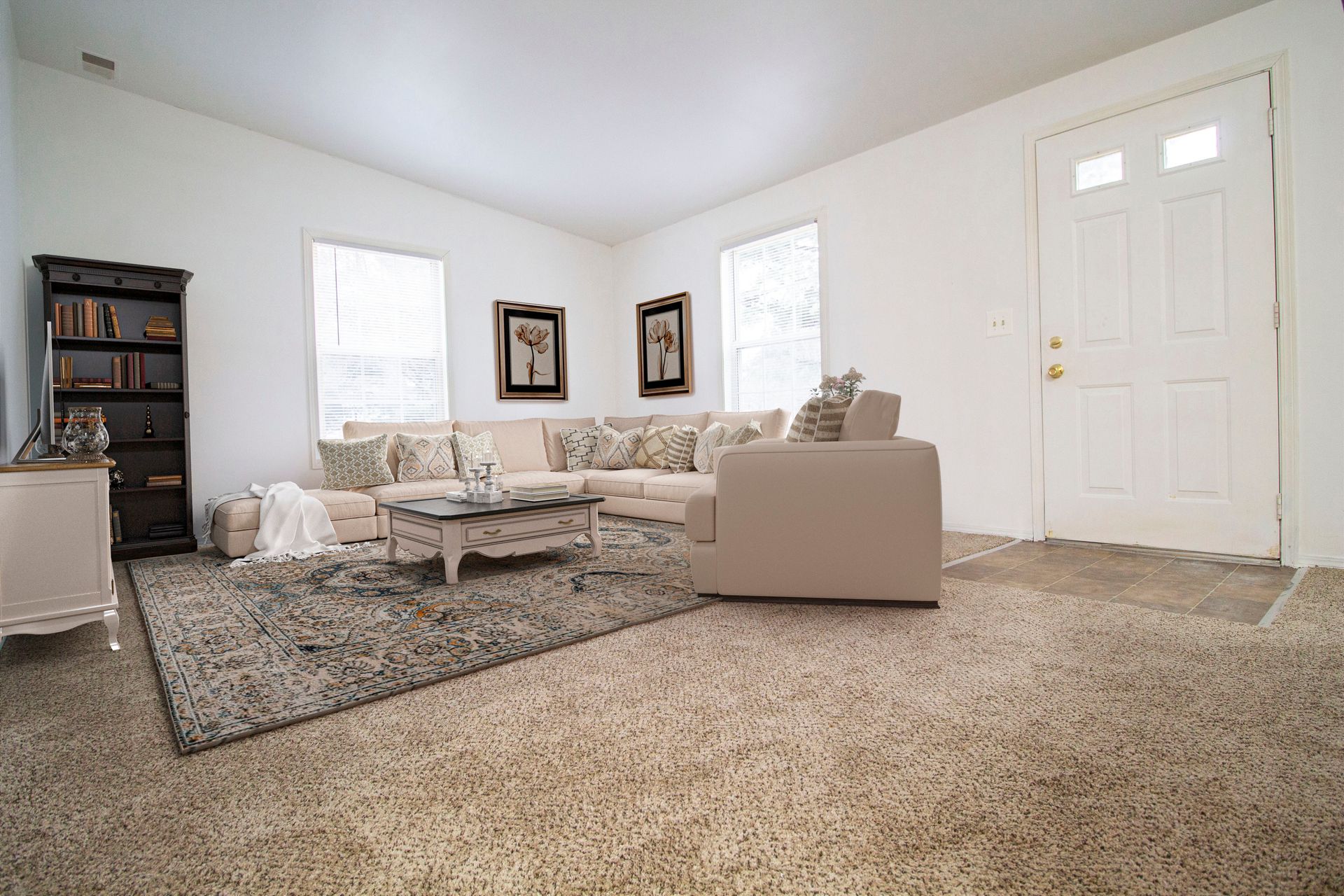 A living room with a couch , chair , coffee table and rug.