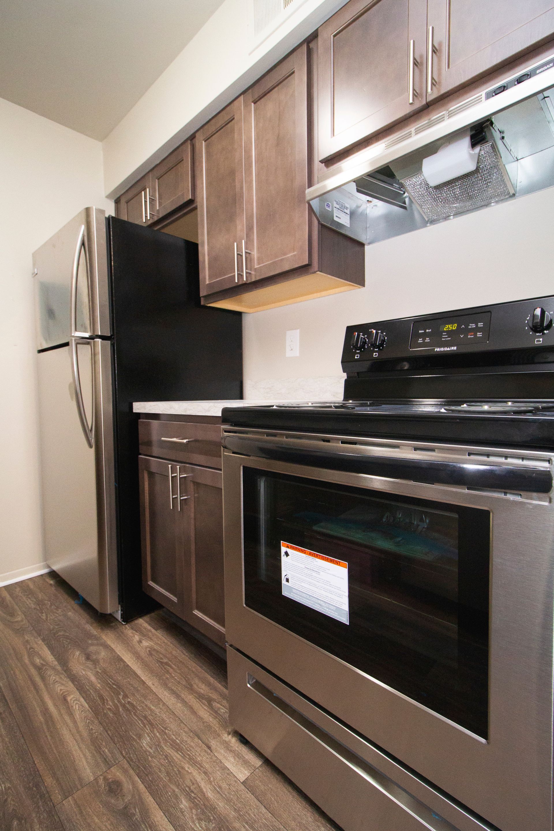 A kitchen with a stove , refrigerator , and oven.