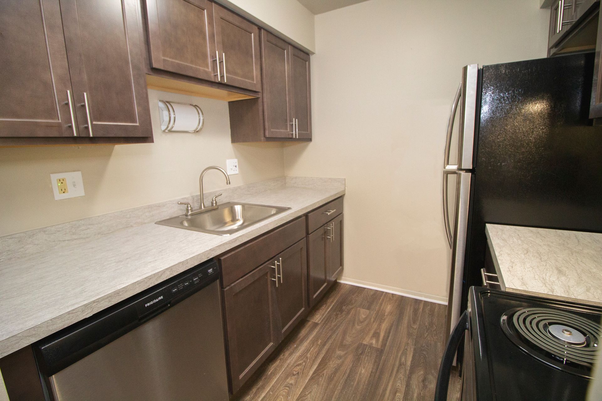 A kitchen with stainless steel appliances and wooden floors.