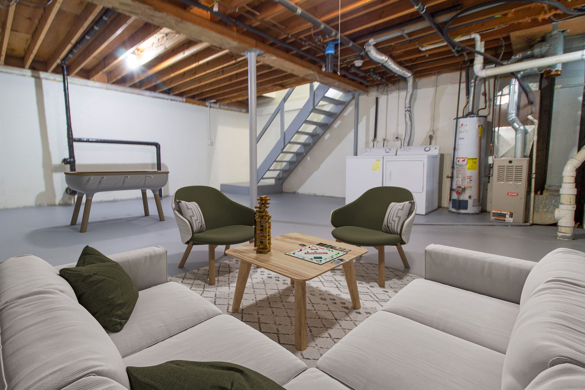 A living room in a basement with a couch , chairs , and a table.
