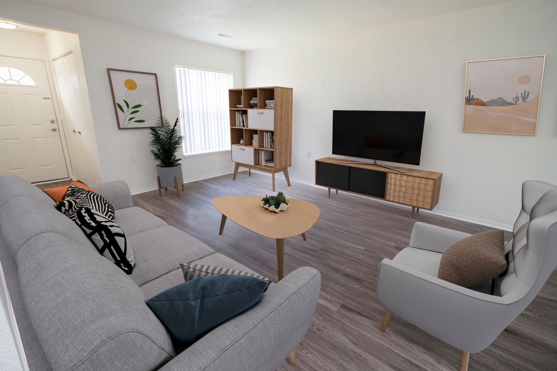 A living room with a couch , chair , coffee table and television.