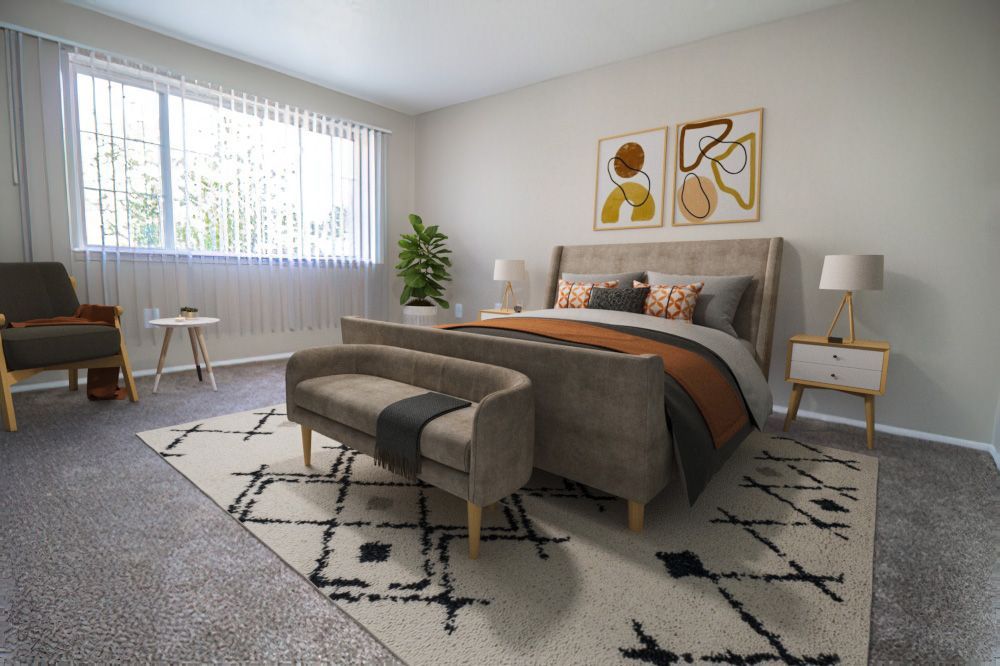 A bedroom with a bed , chair , nightstand and rug.