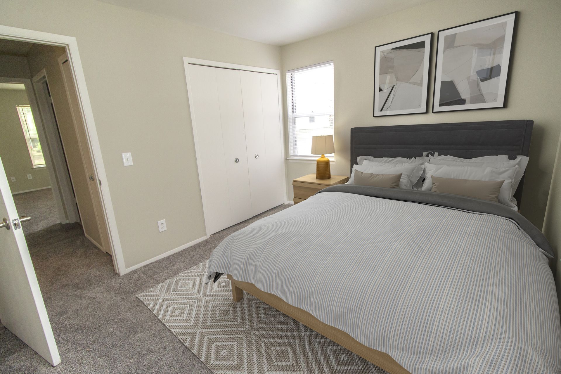 A bedroom with a bed , nightstand , lamp and closet.
