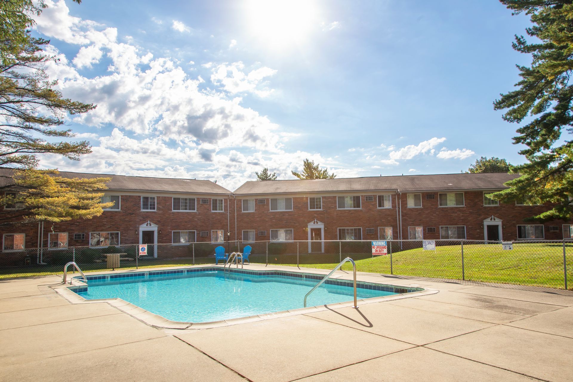 A large swimming pool in front of a brick building