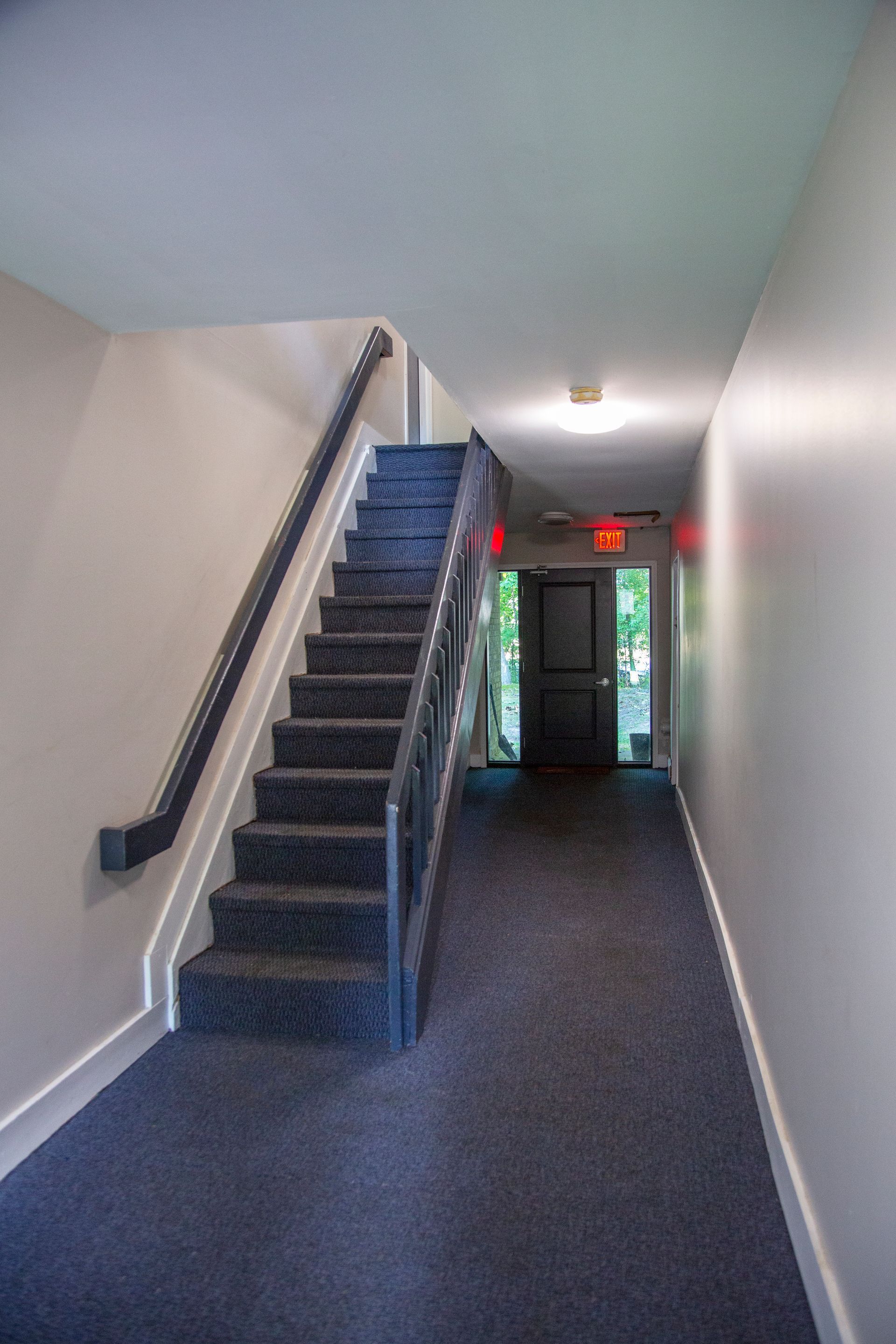 A hallway with stairs leading up to the second floor of a building.