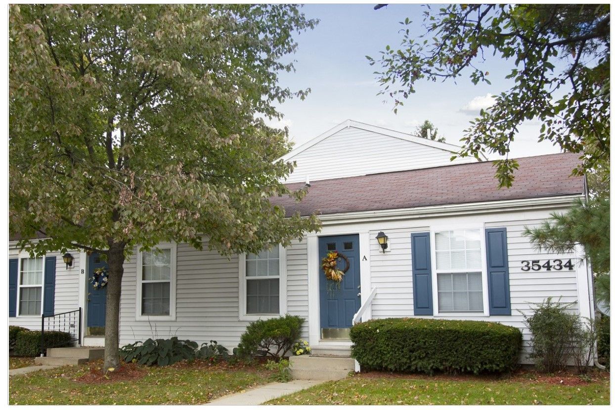 A white house with blue shutters and the number 35434 on the front
