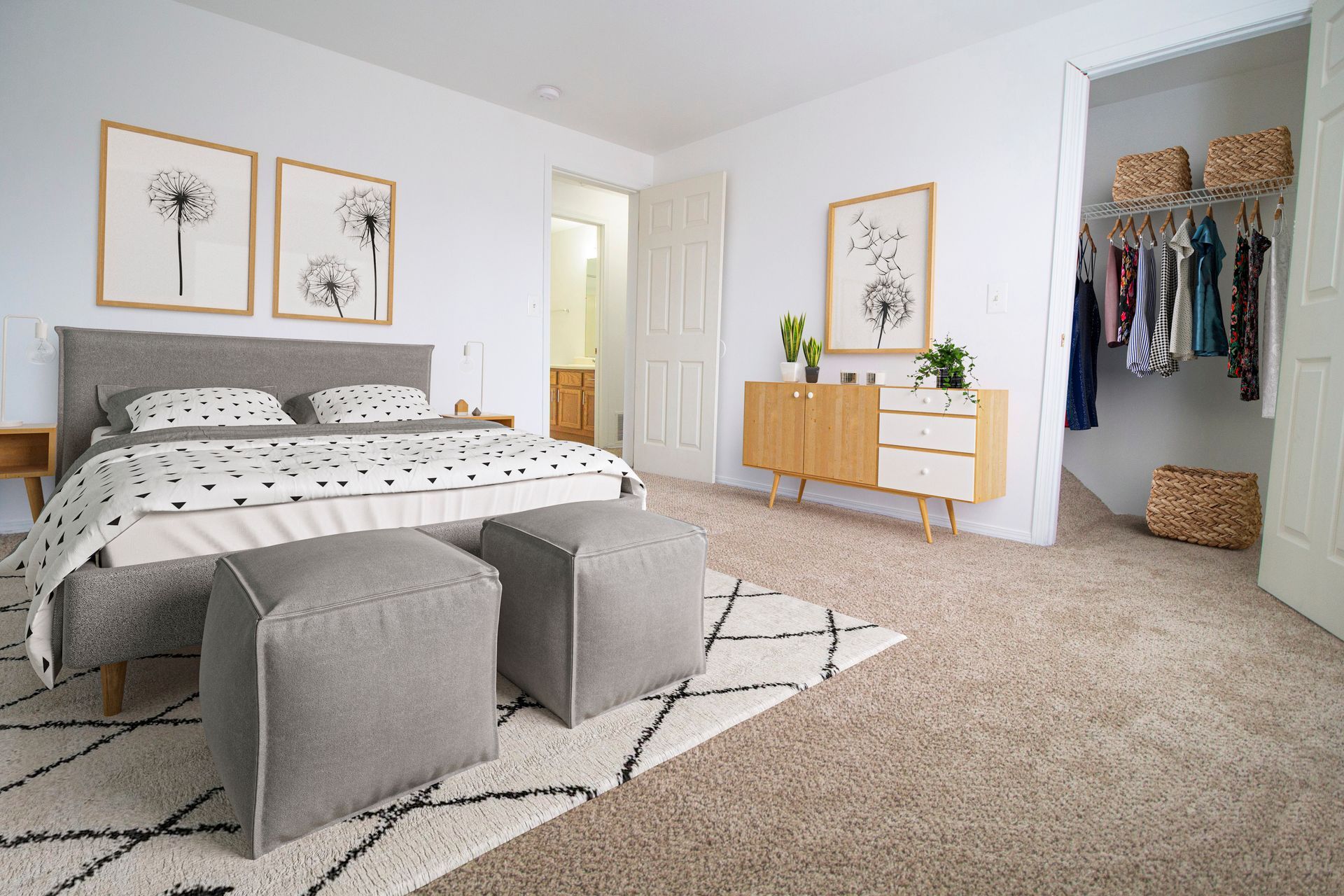 A bedroom with a bed , ottomans and a walk in closet.