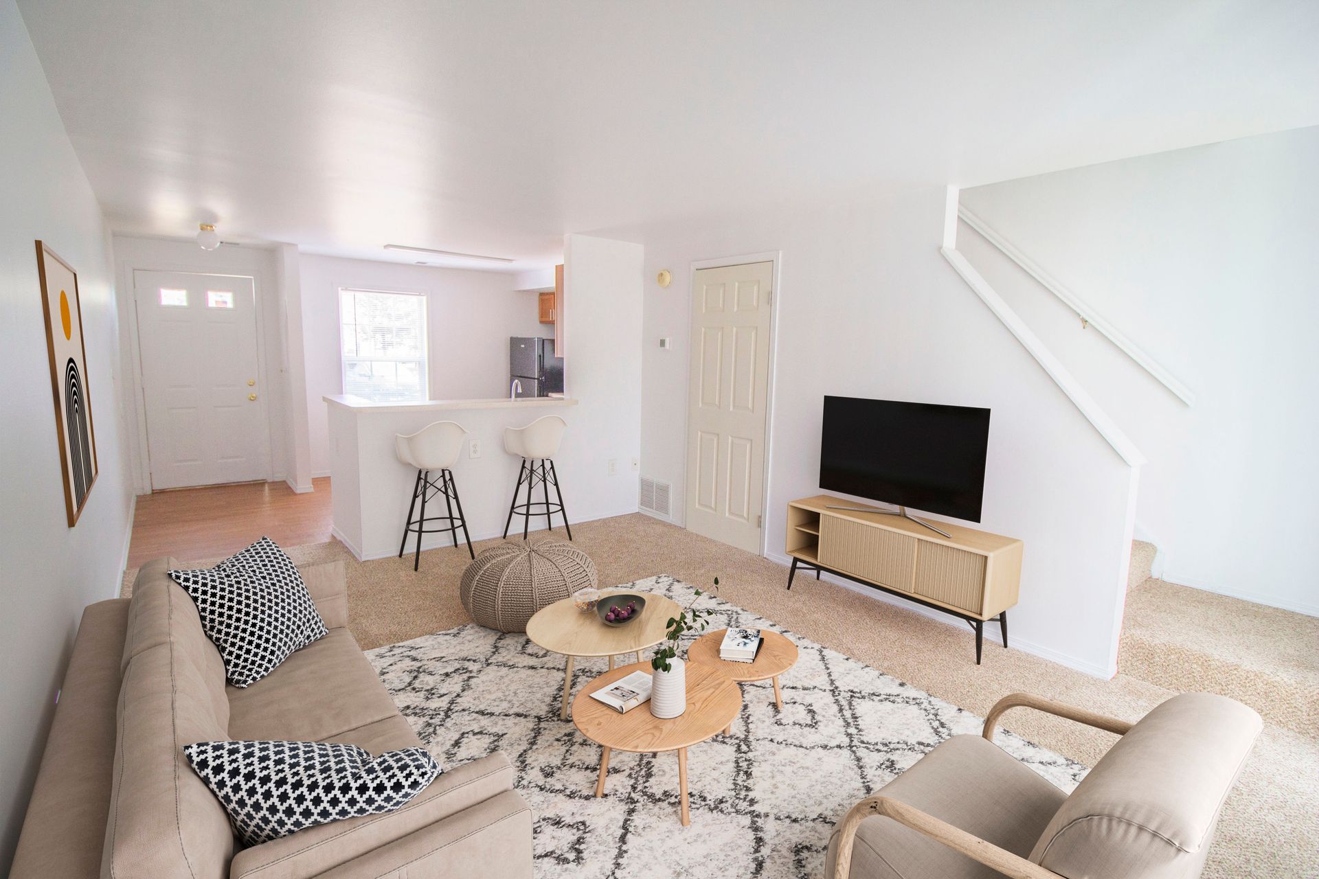 A living room with a couch , chair , table and television.
