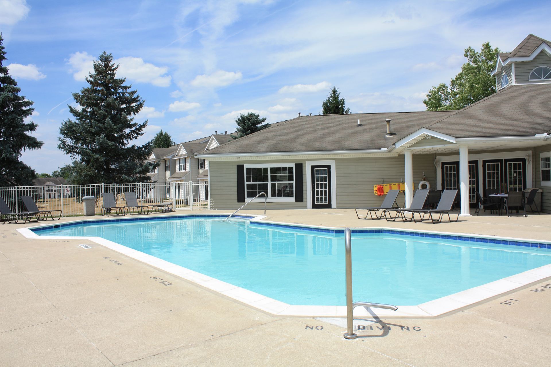 A large swimming pool in front of a house