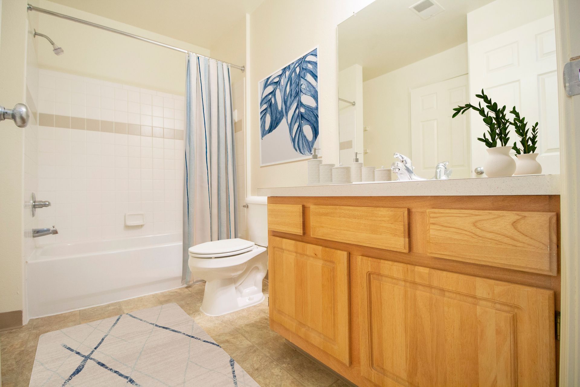 A bathroom with a toilet , sink , bathtub and mirror.