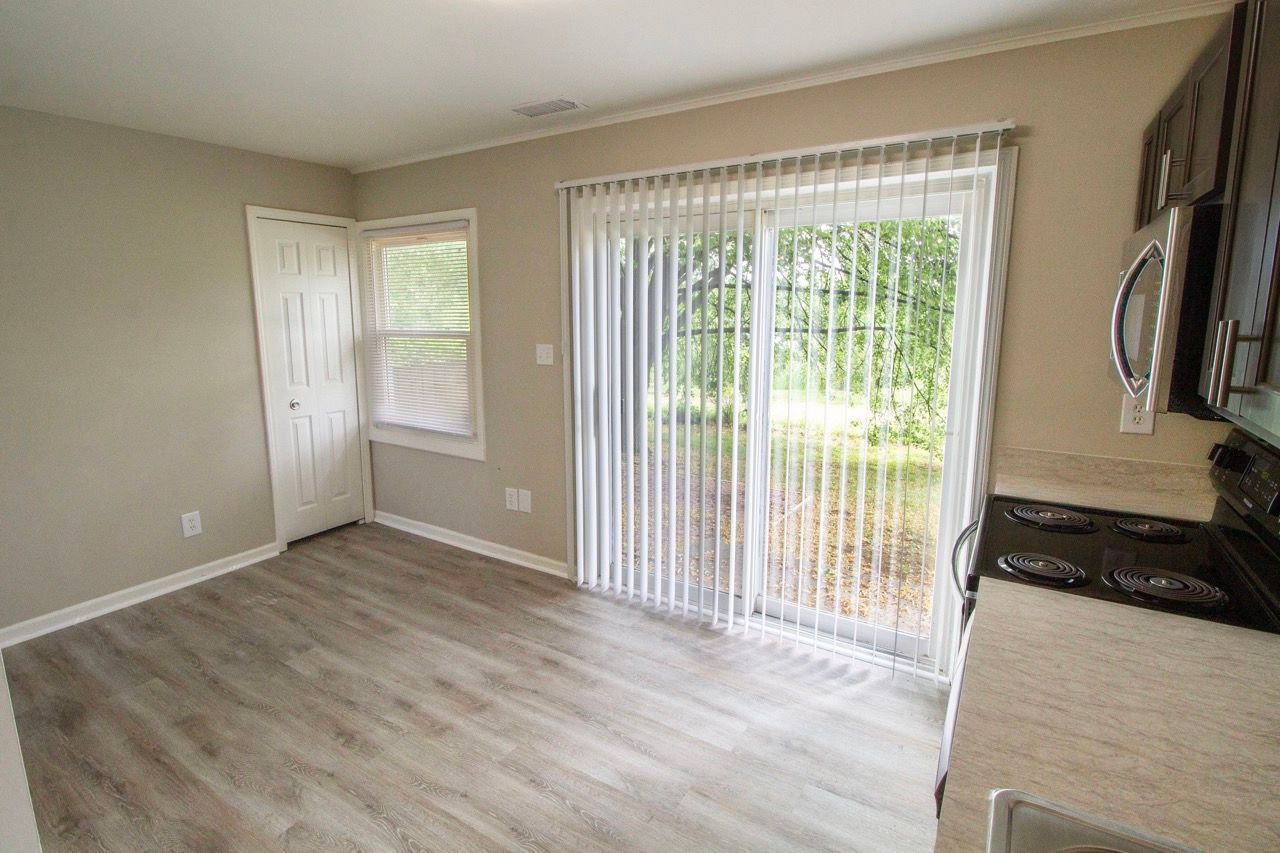 A living room with a sliding glass door leading to a patio.