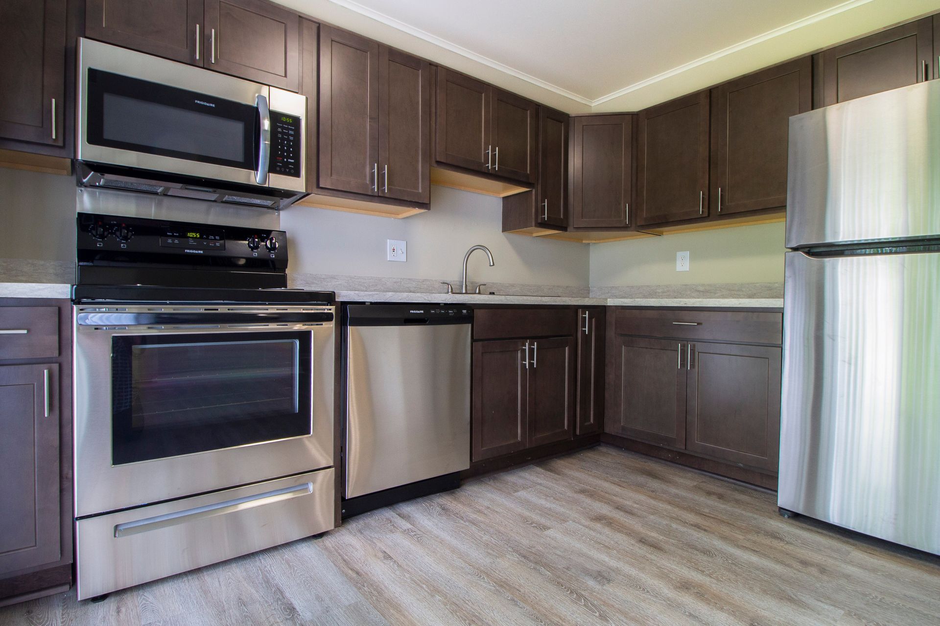 A kitchen with stainless steel appliances and brown cabinets