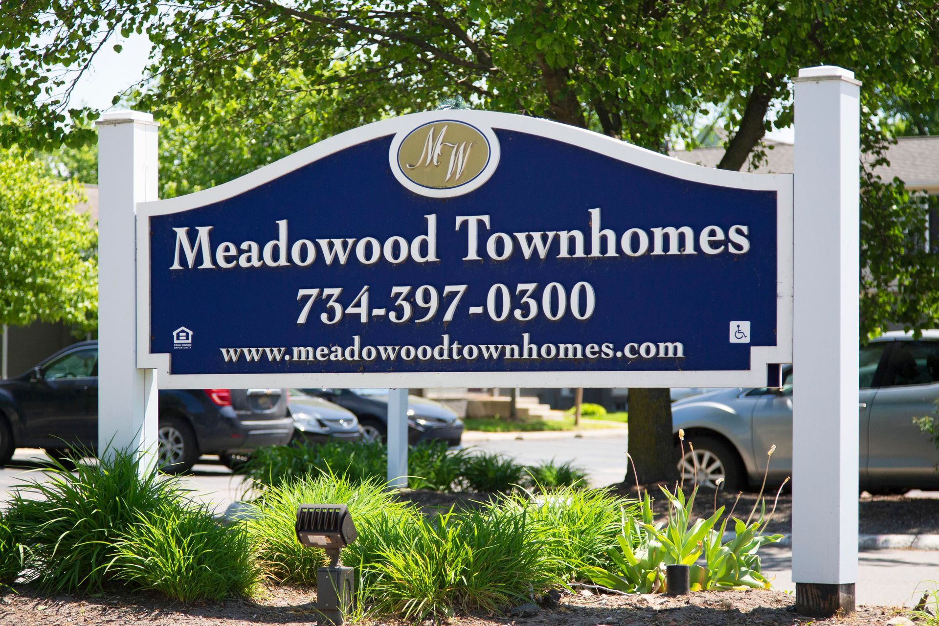 A blue and white sign for meadowood townhomes
