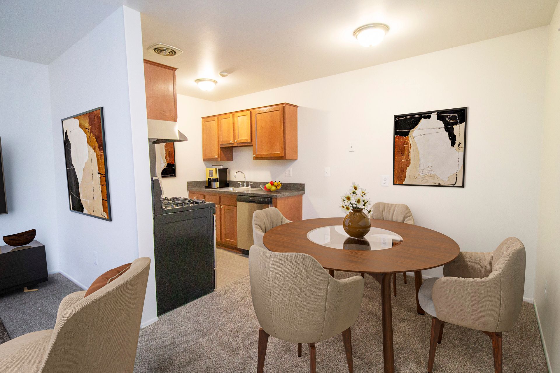 A living room with a table and chairs and a kitchen