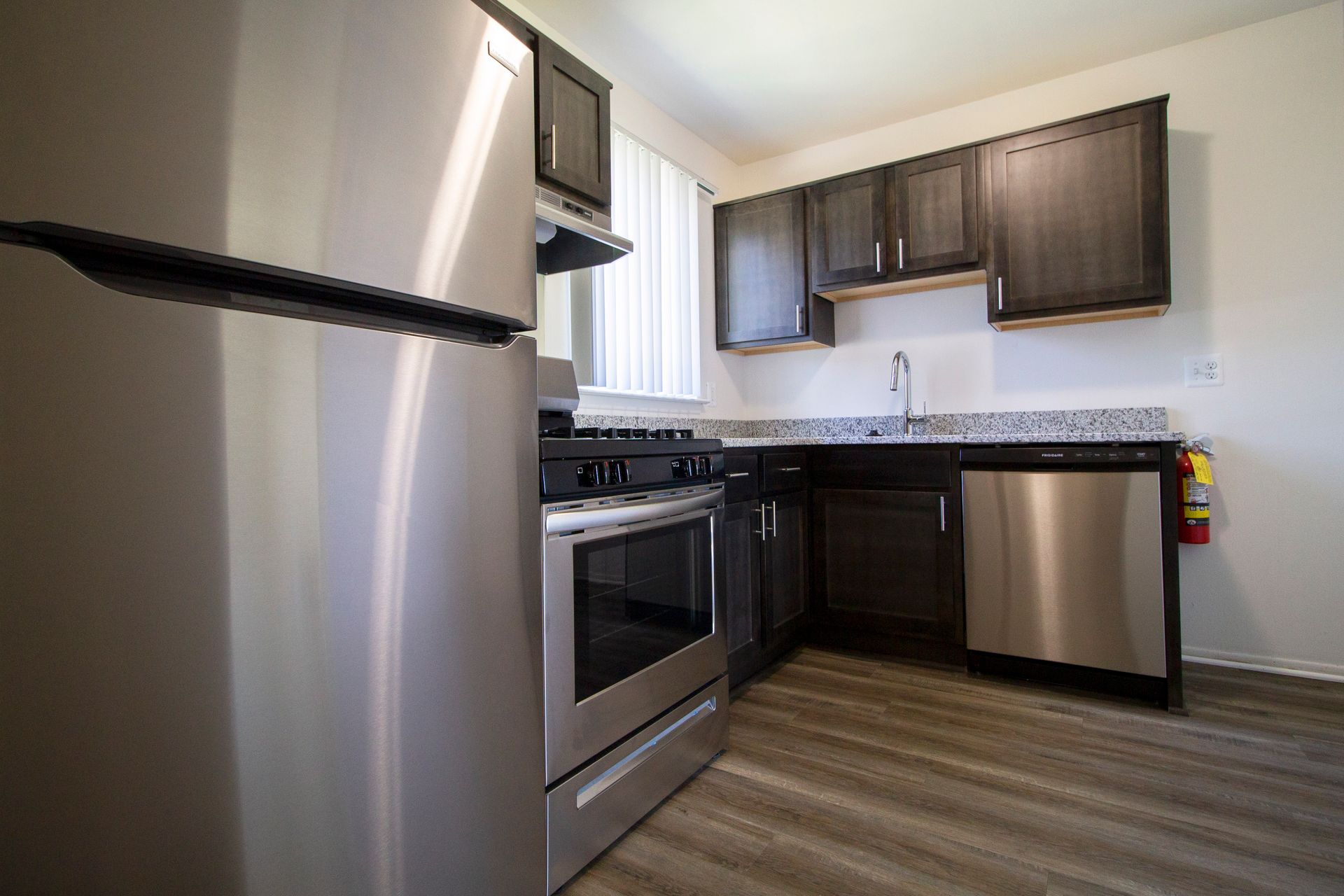 A kitchen with stainless steel appliances and wooden floors