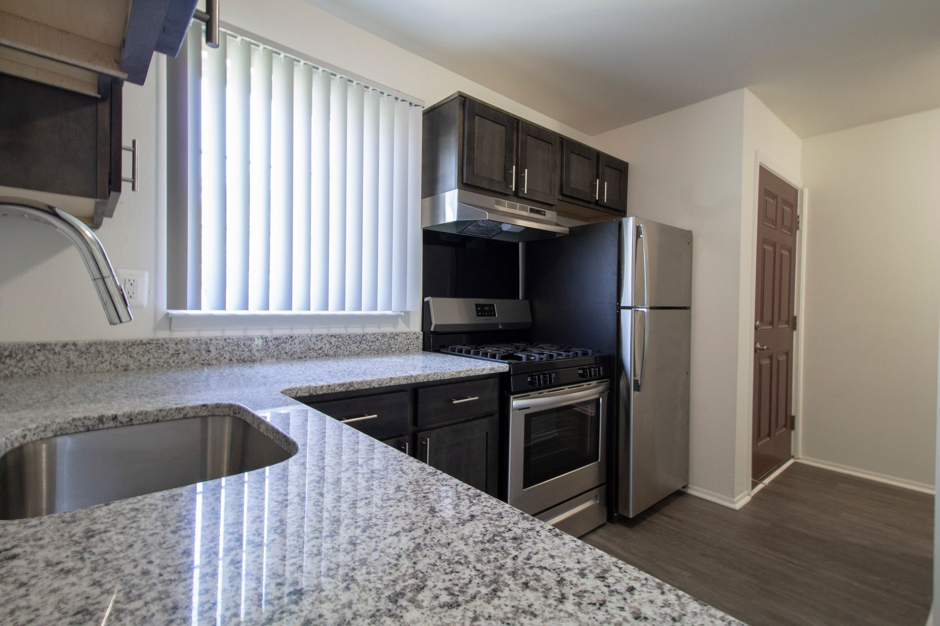 A kitchen with stainless steel appliances and granite counter tops.