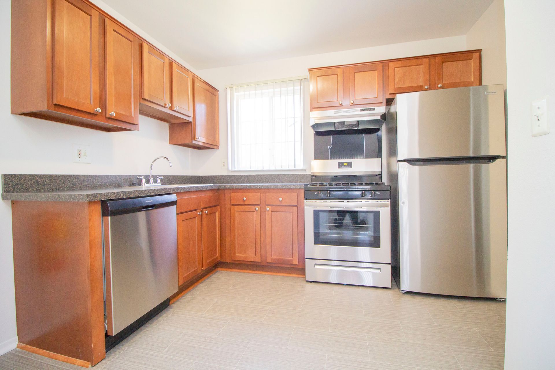 A kitchen with stainless steel appliances and wooden cabinets