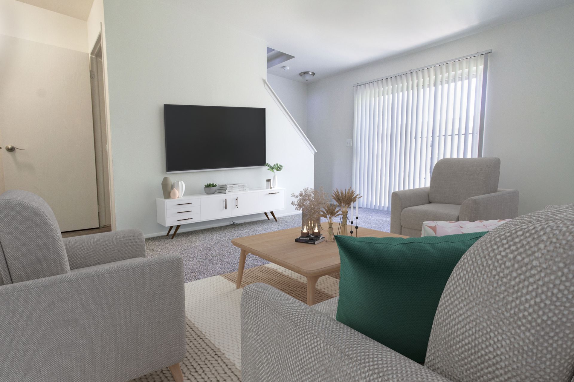 A living room with a couch , chair , coffee table and television.