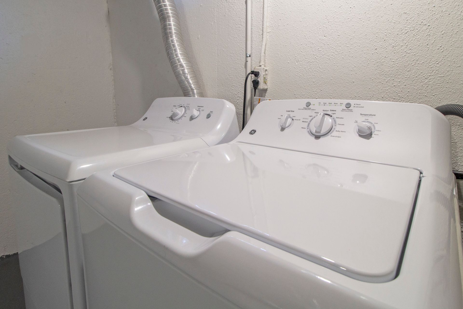A washer and dryer are sitting next to each other in a laundry room.