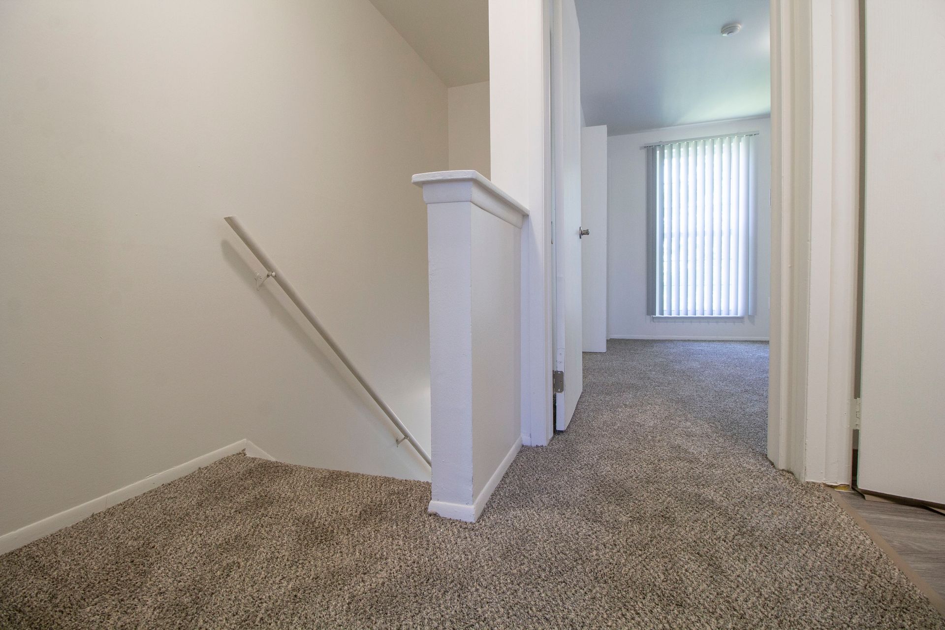 A hallway with stairs leading up to the second floor of a house.