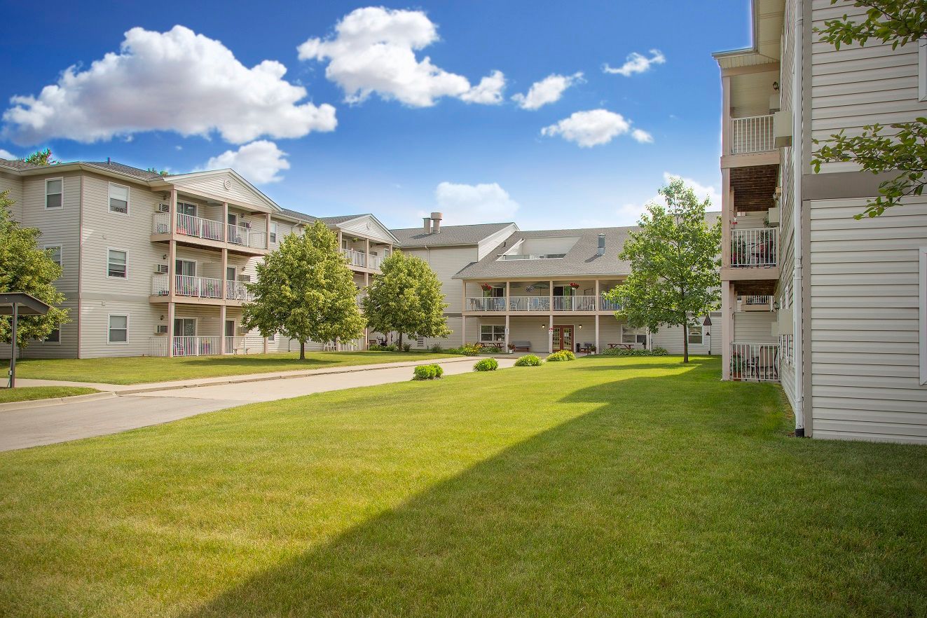 A large apartment building with a lush green lawn in front of it.
