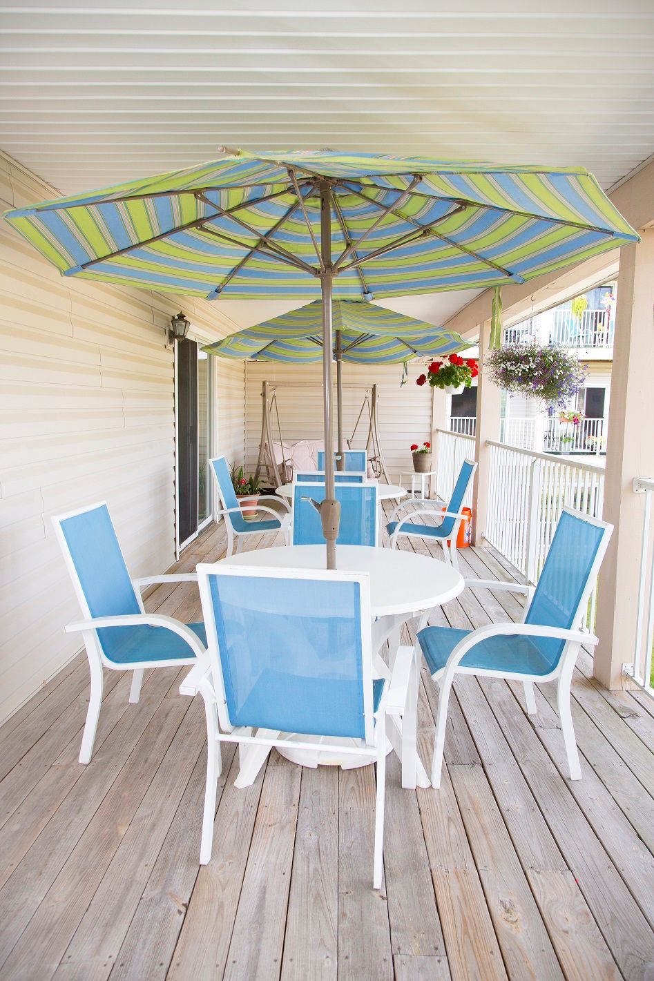 A porch with a table and chairs under an umbrella.