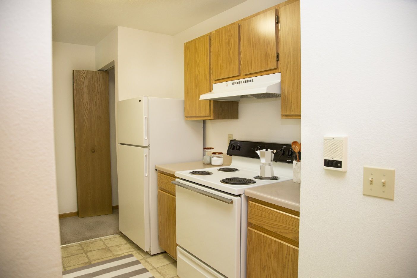 A kitchen with a stove , refrigerator and cabinets
