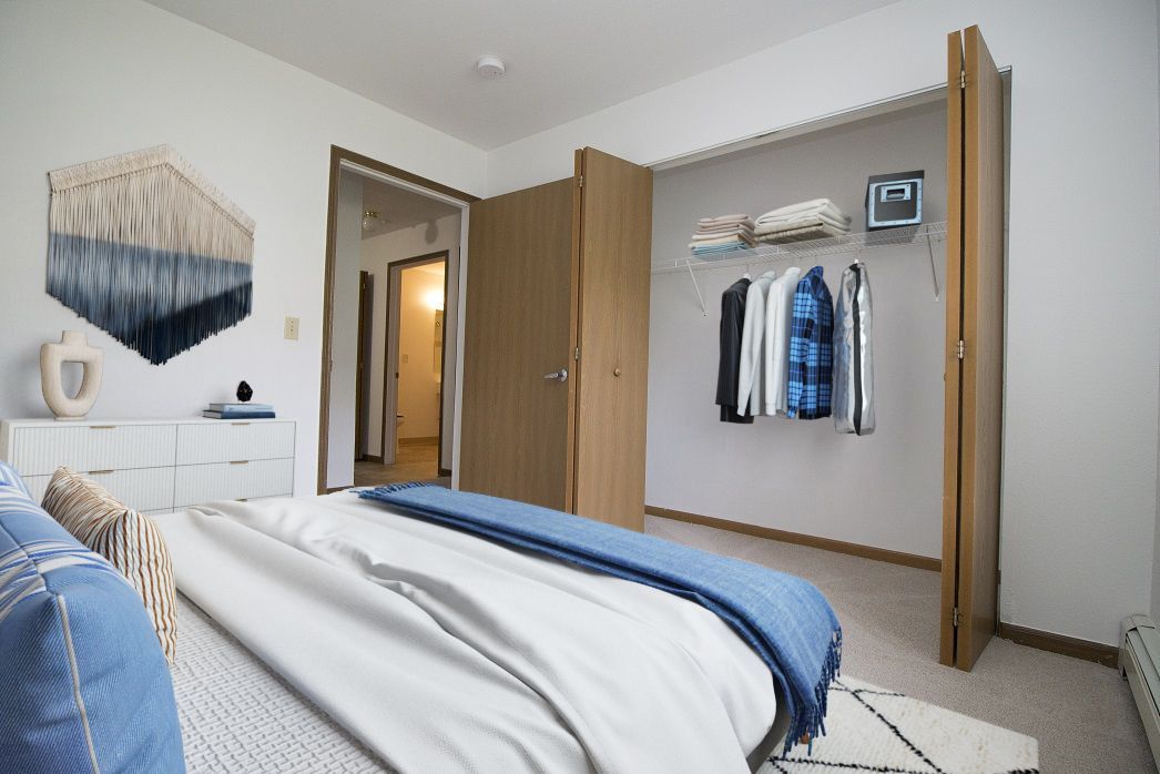 A bedroom with a large bed and a walk in closet.