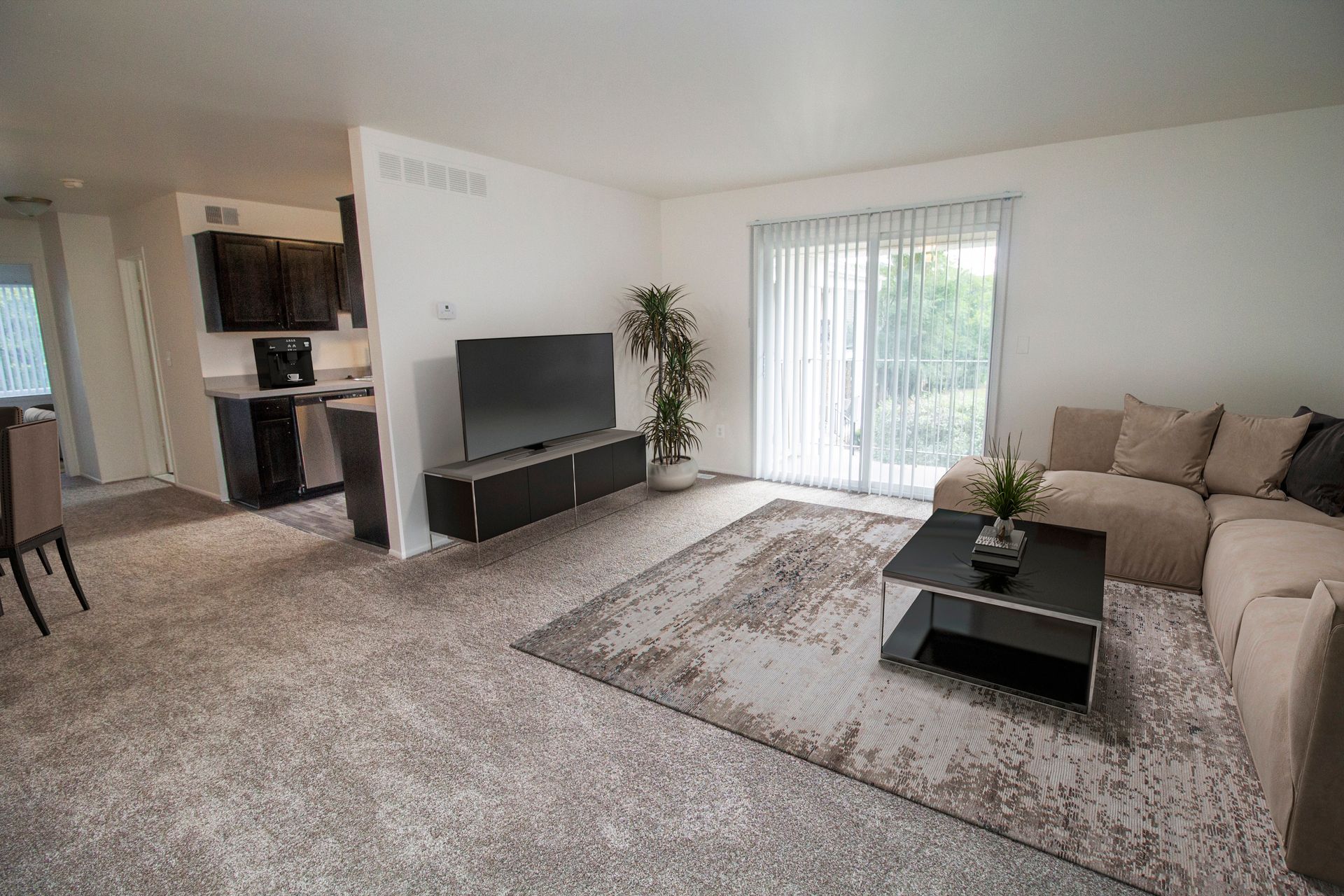 A living room with a couch , television , coffee table and rug.