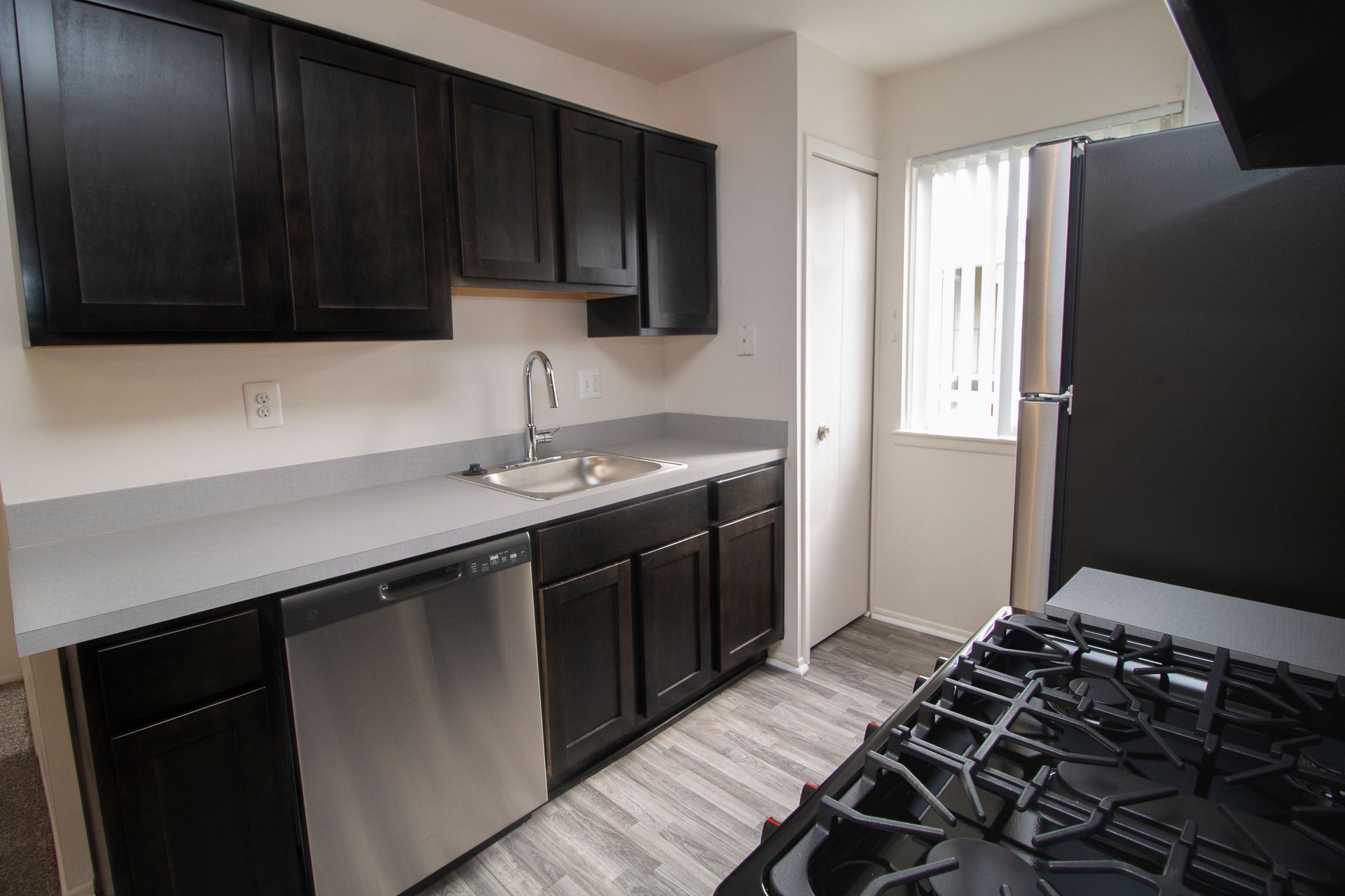 A kitchen with black cabinets and stainless steel appliances