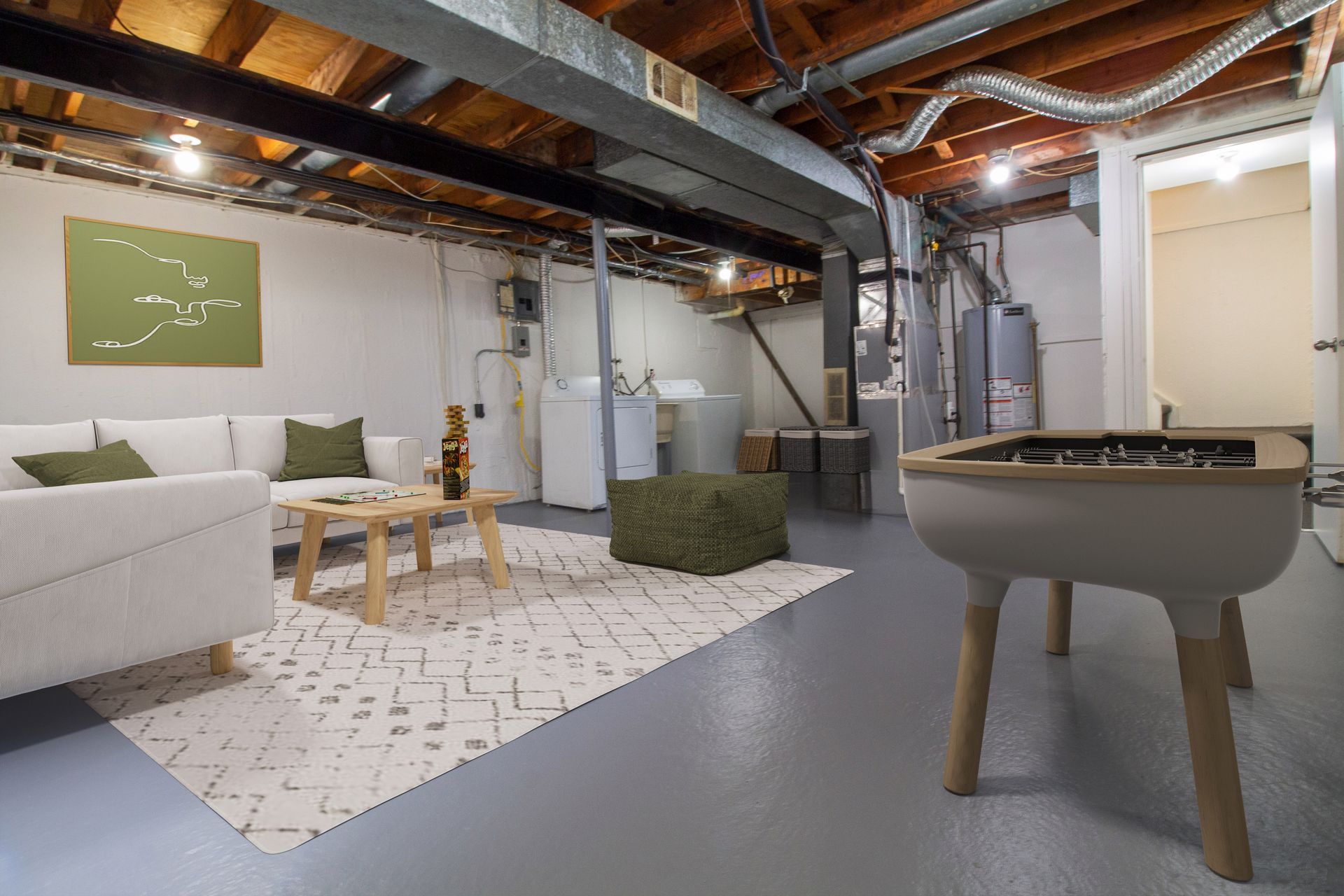 A living room in a basement with a game table and a couch.