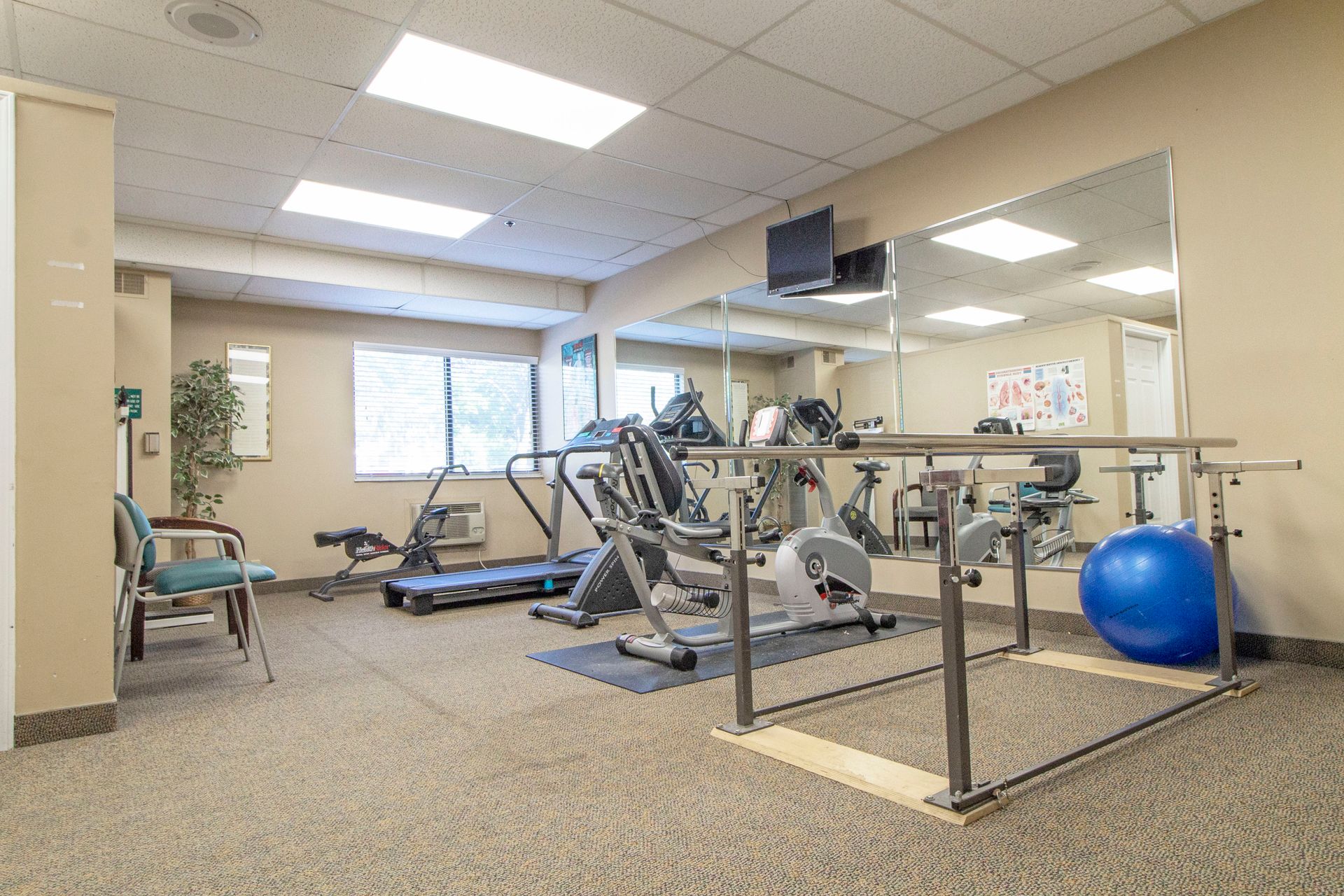 A gym filled with exercise equipment and a large mirror.