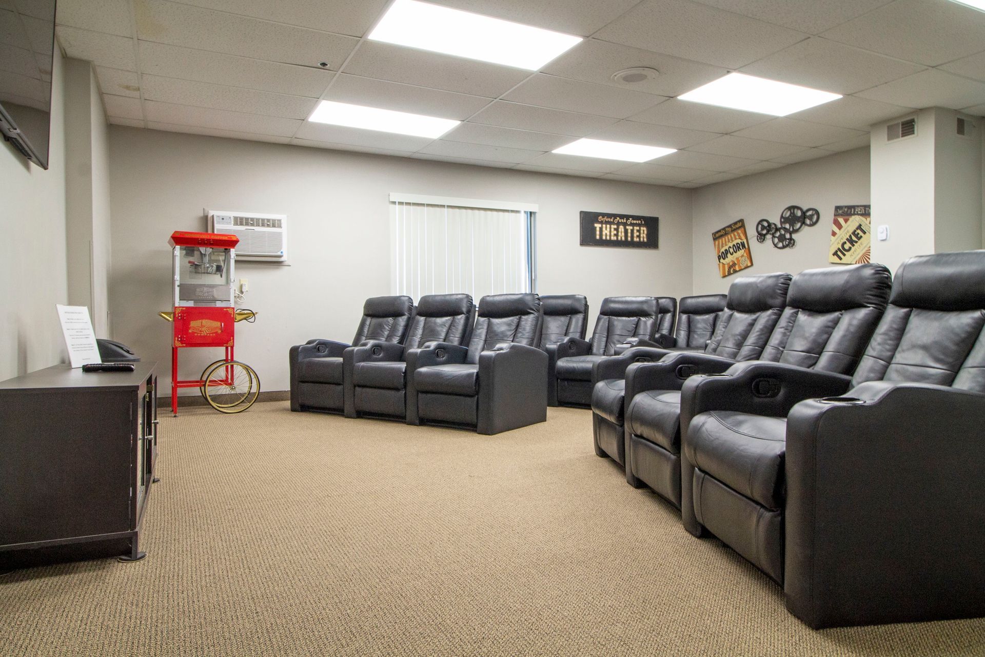 A movie theater with lots of chairs and a popcorn machine.