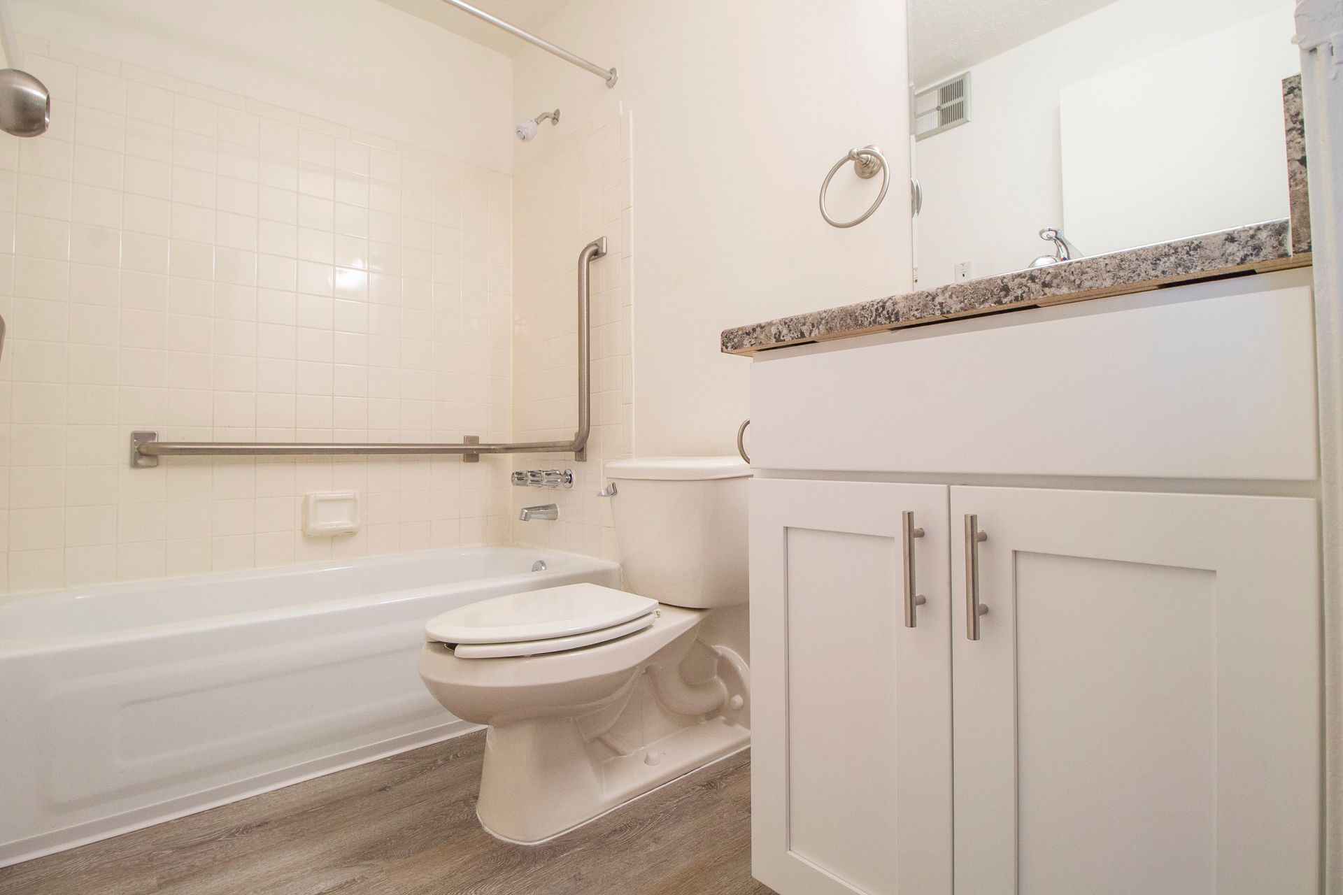 A bathroom with a toilet , sink , bathtub and shower.