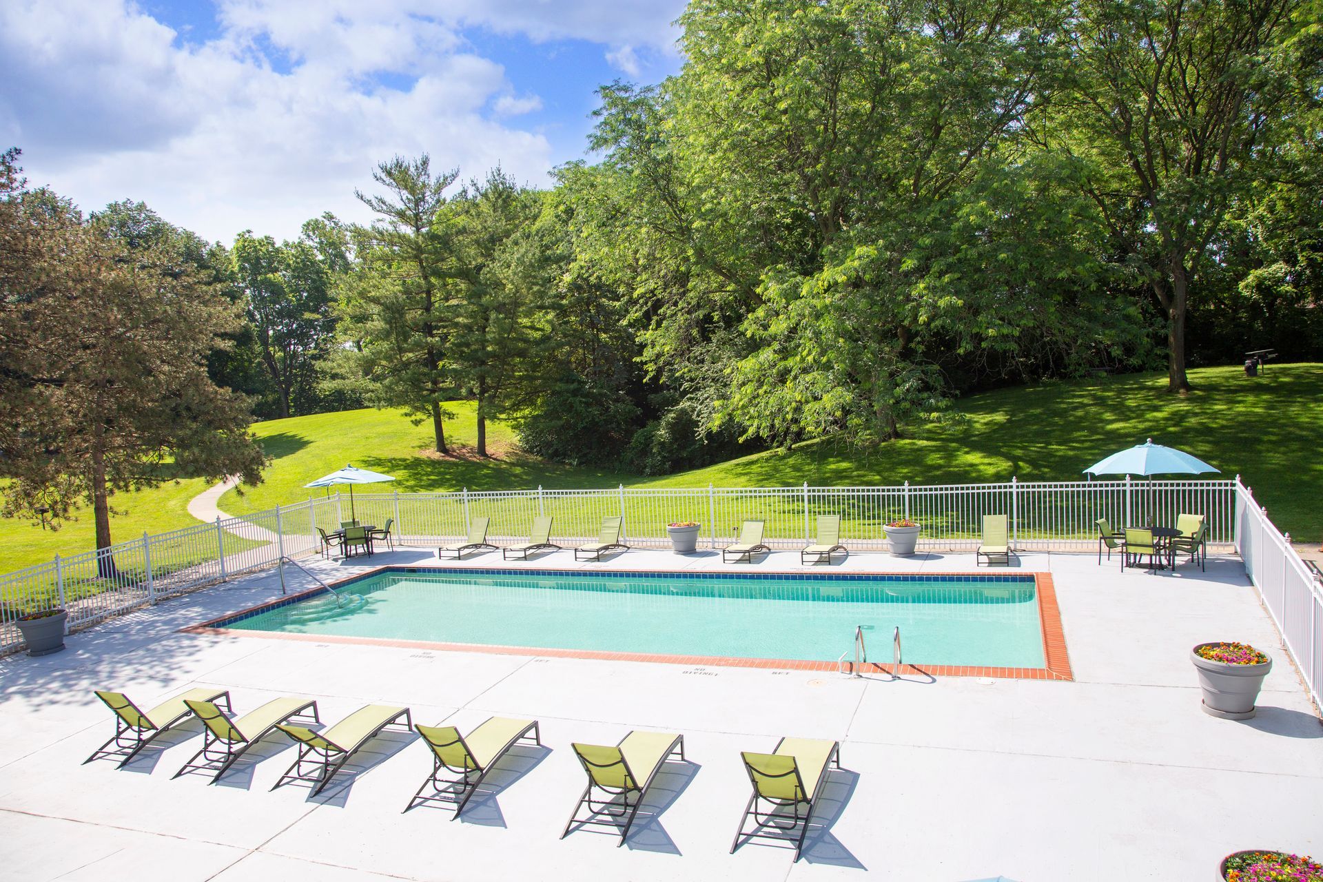 An aerial view of a large swimming pool surrounded by chairs and umbrellas.
