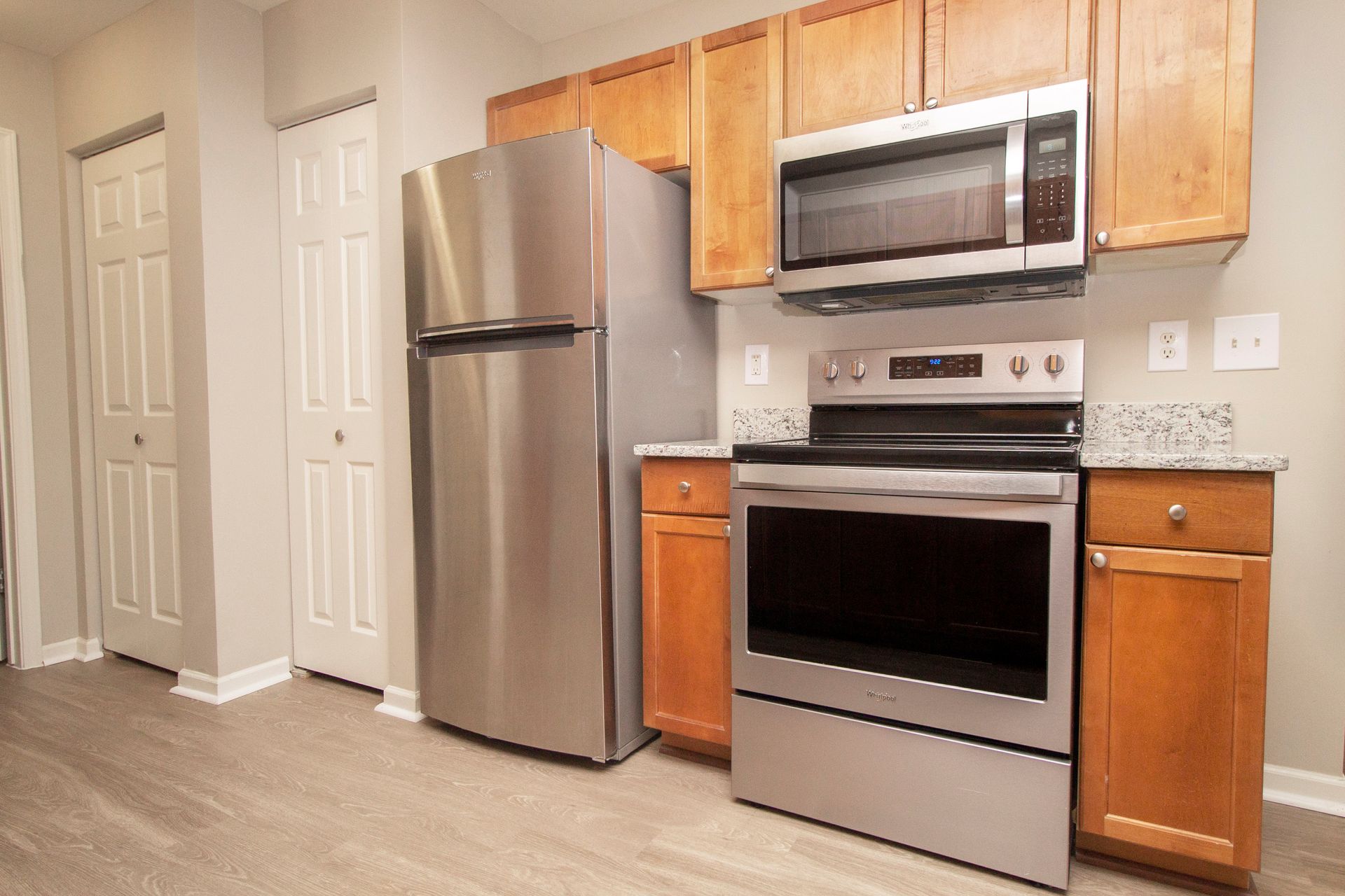 A kitchen with stainless steel appliances and wooden cabinets.