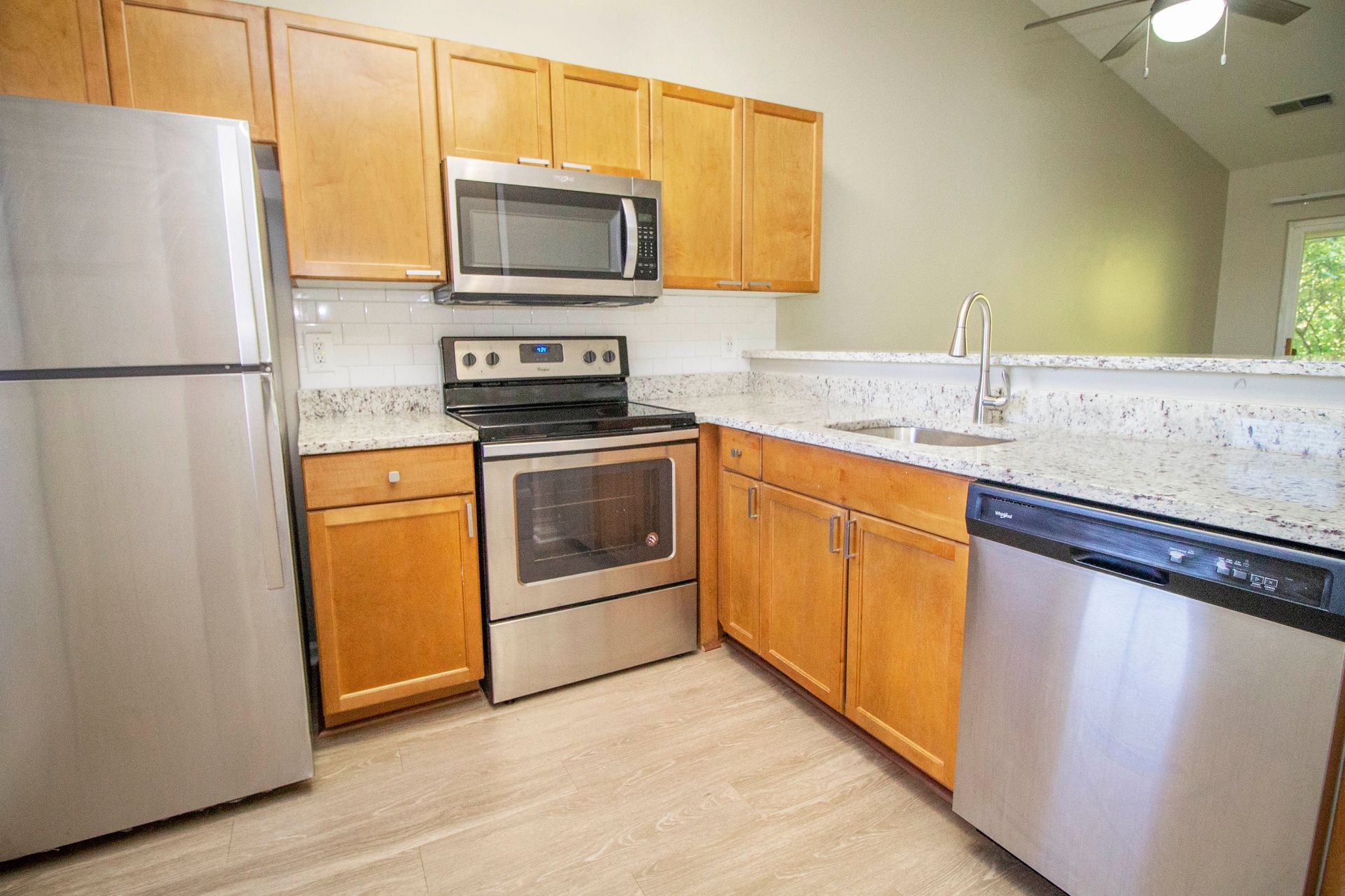 A kitchen with stainless steel appliances and wooden cabinets.