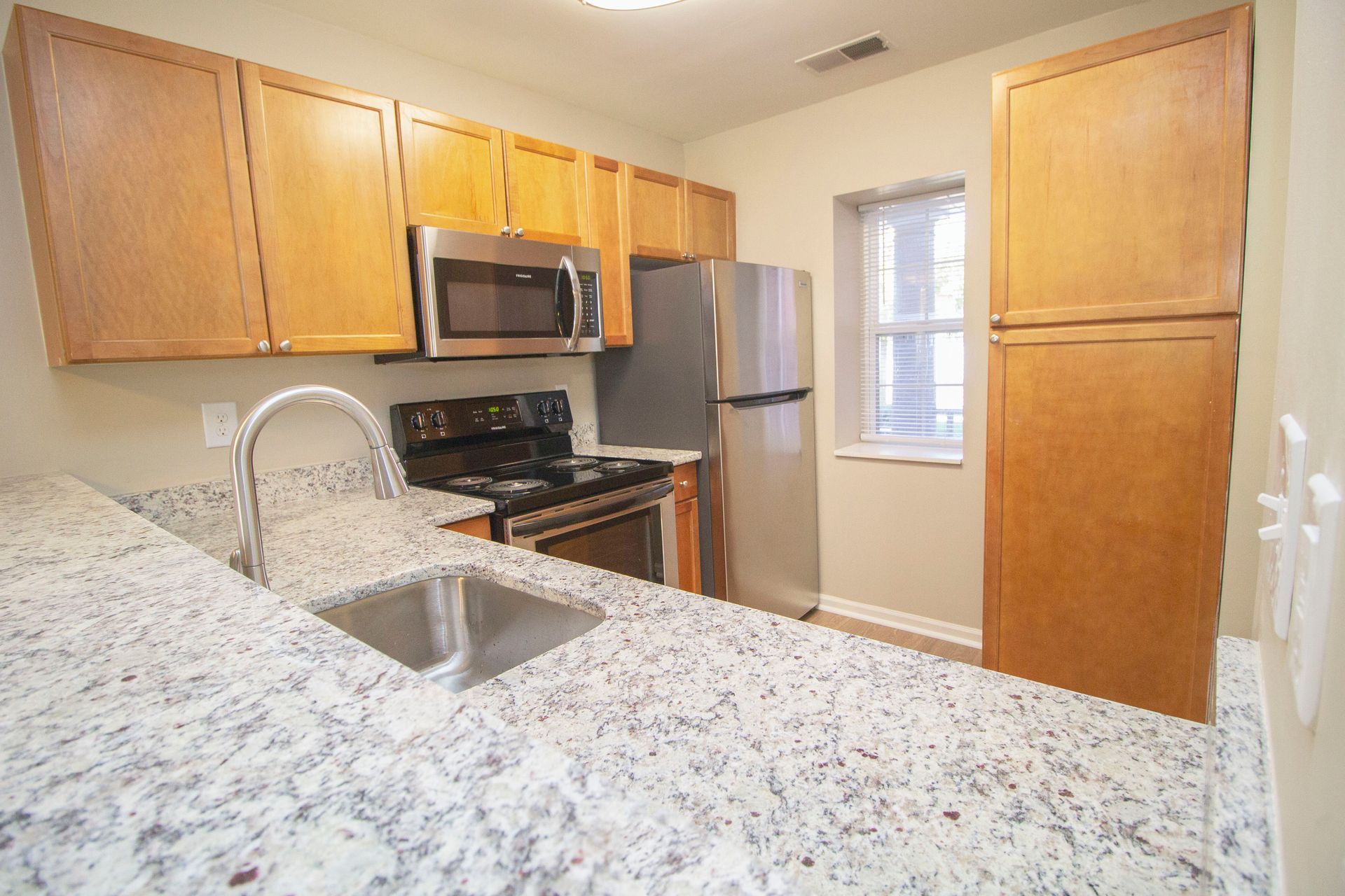 A kitchen with granite counter tops and stainless steel appliances