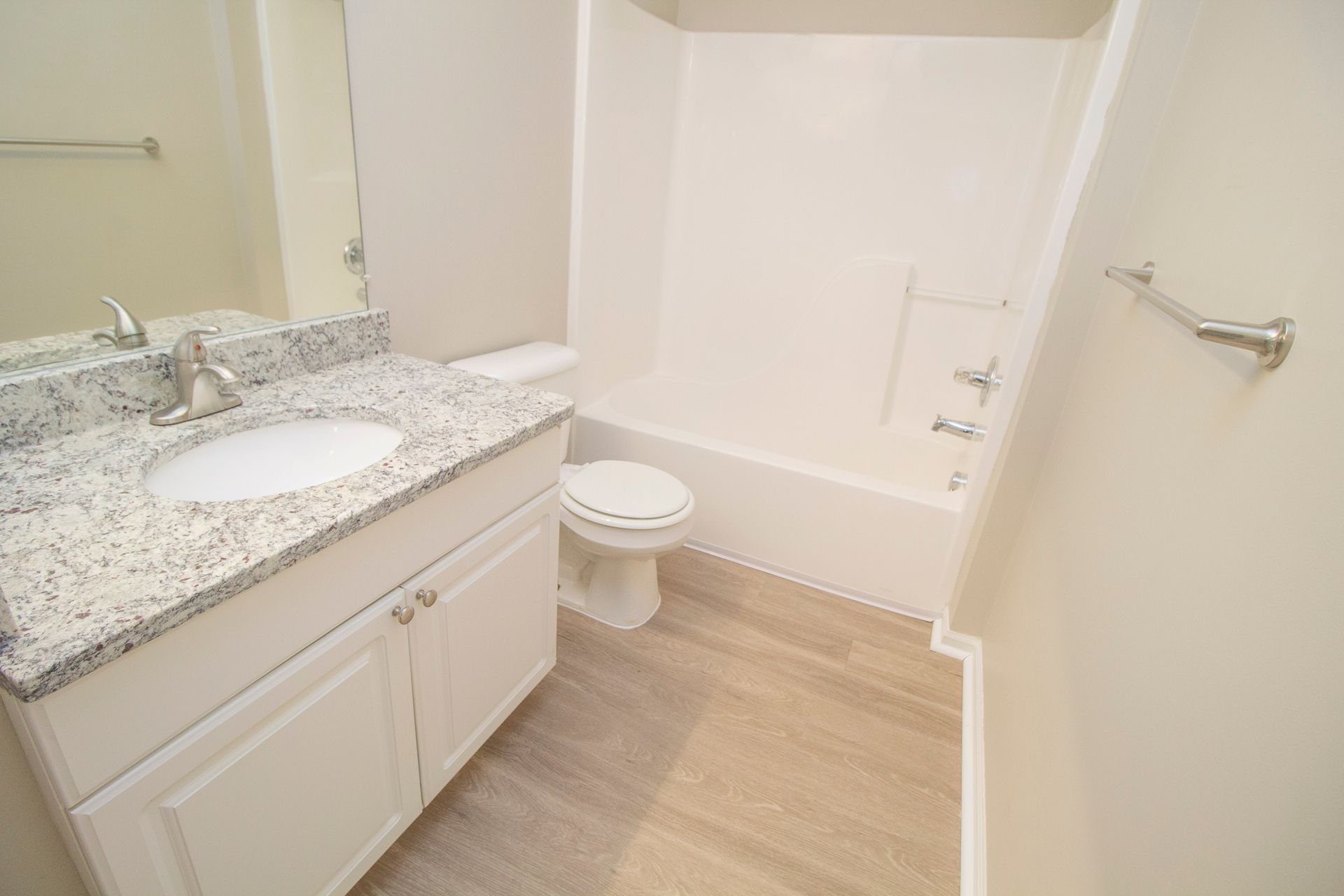 A bathroom with a sink , toilet , bathtub and mirror.