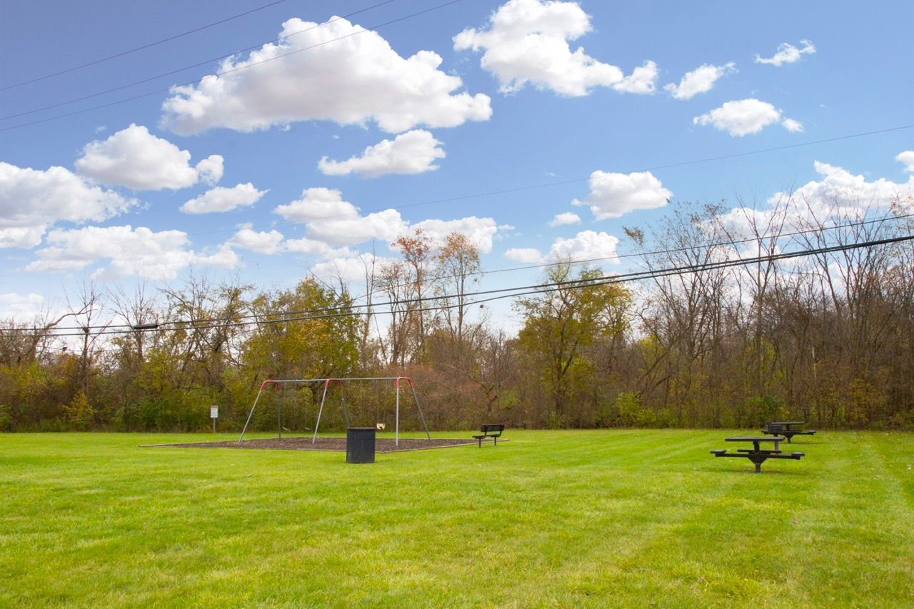 There is a picnic table in the middle of a grassy field.