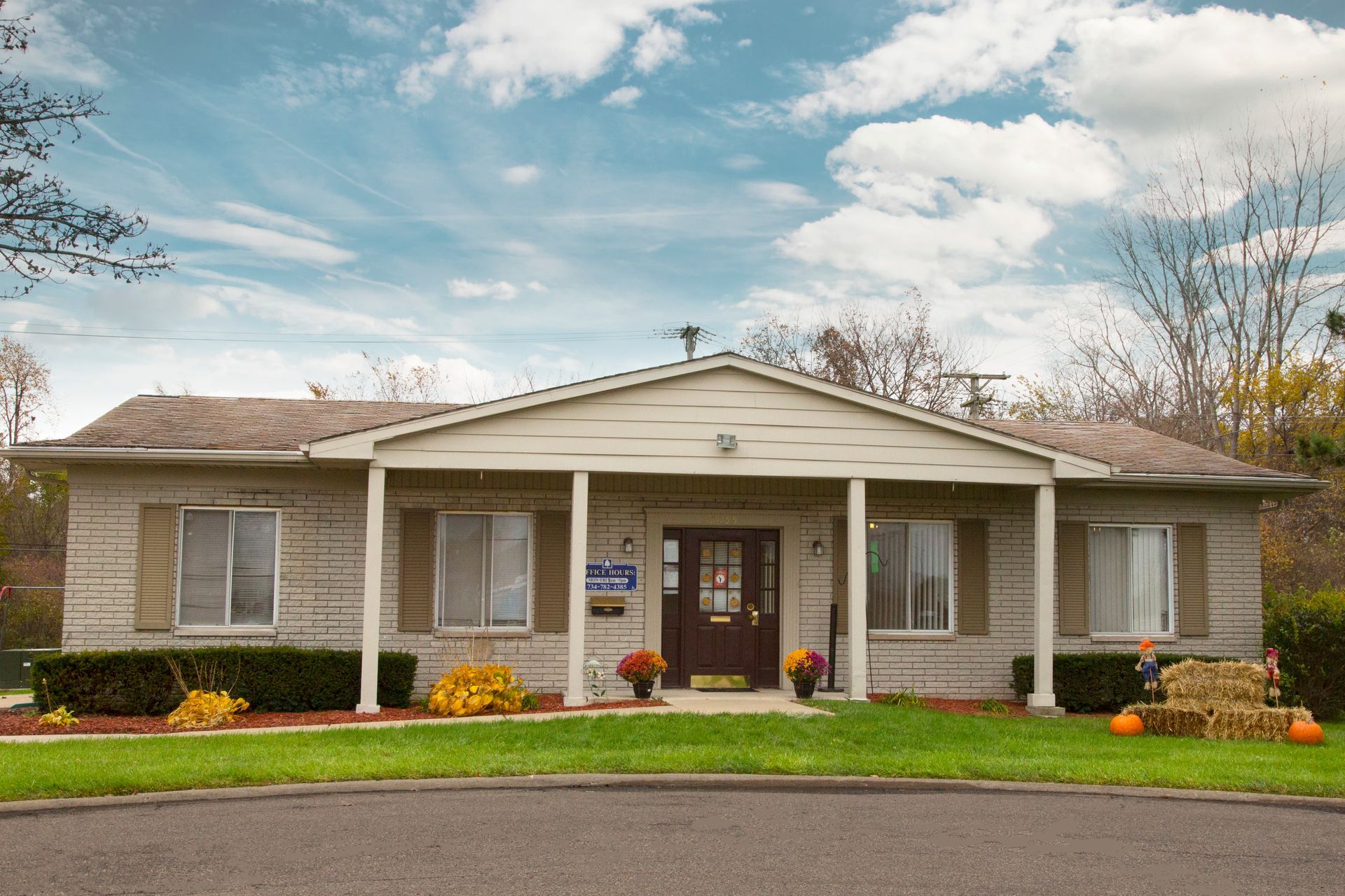A white house with a porch and a blue sky in the background
