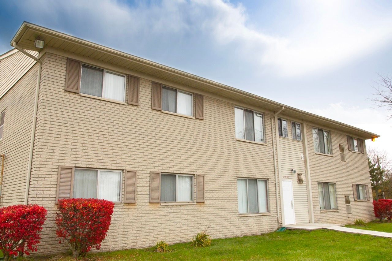 A brick apartment building with a lot of windows and shutters