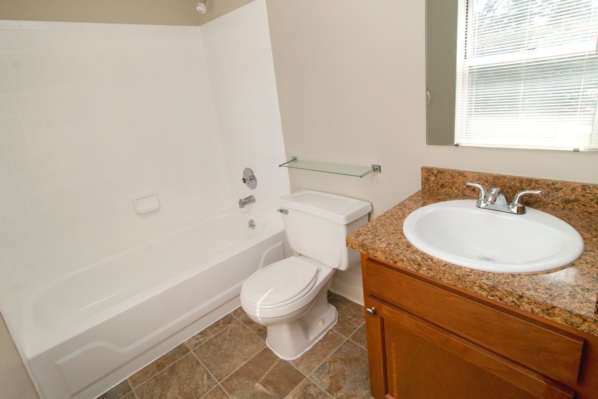 A bathroom with a toilet , sink and bathtub.